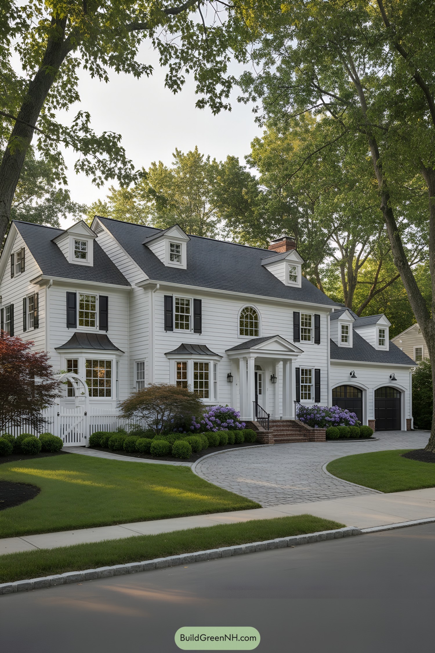 White clapboard Colonial-style house with black shutters and arched dormers