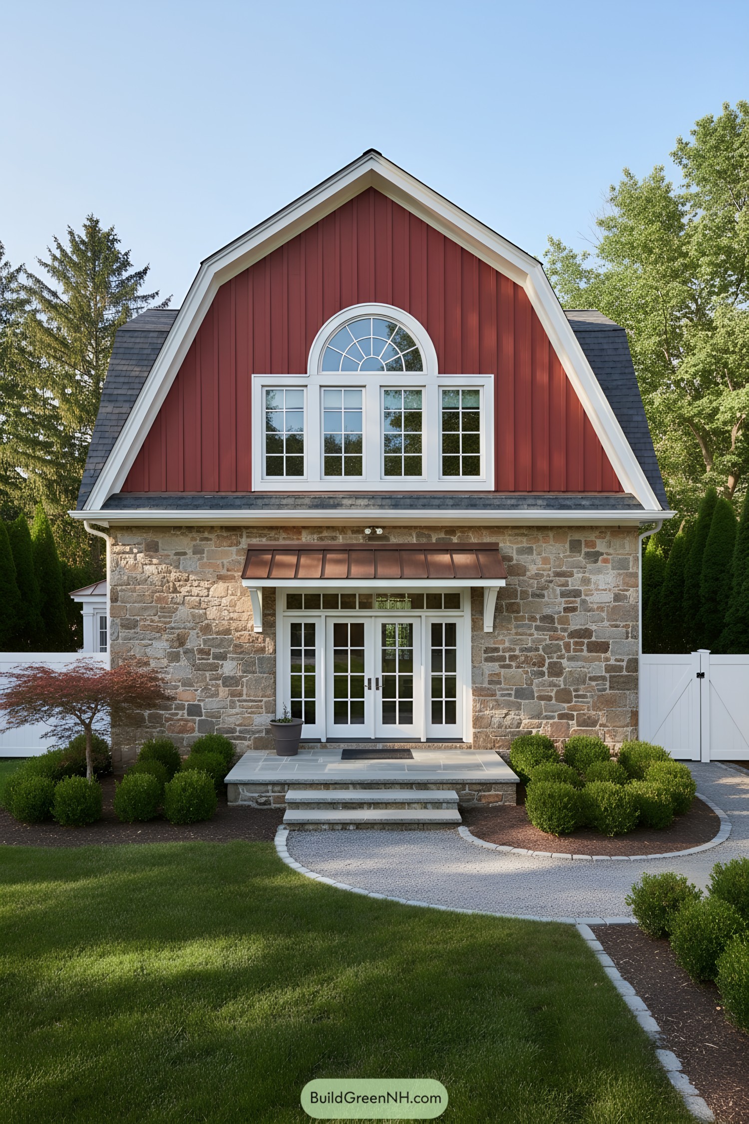 Red gambrel-roof barn home with stone base and arched dormer window