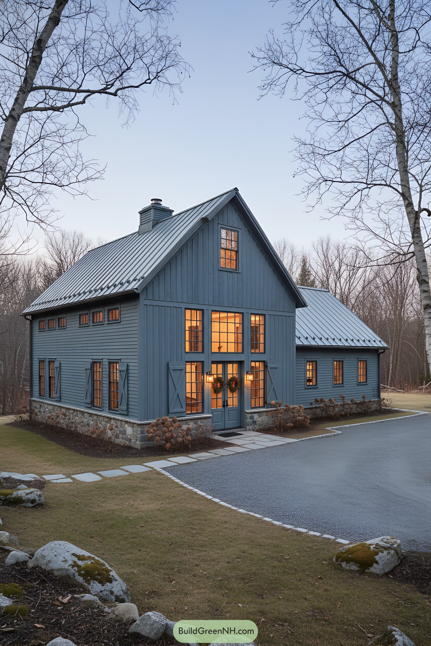 Blue barn-style home with warm lit windows at dusk