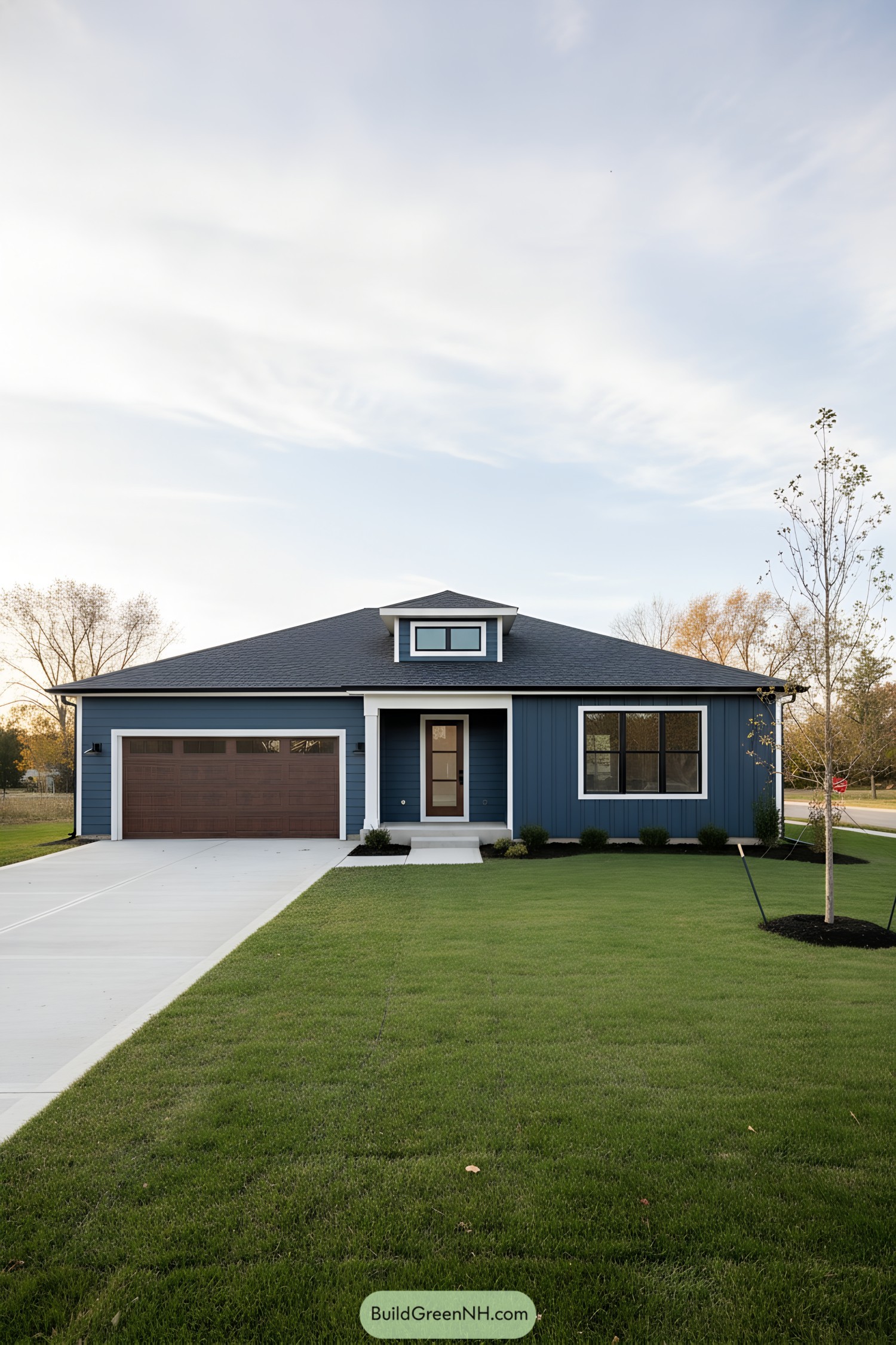 Blue single-story ranch with dark roof and wood-tone garage door