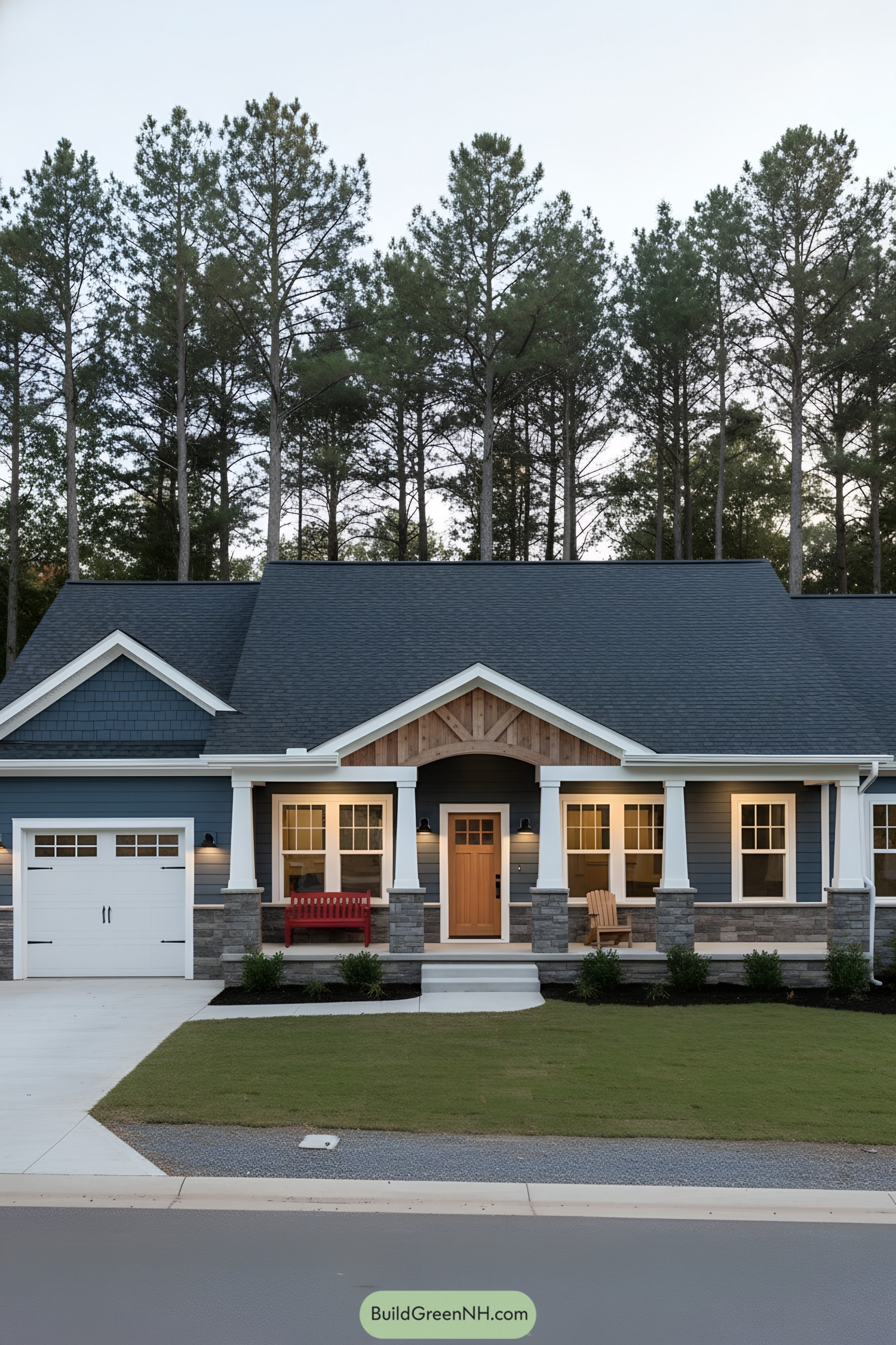 Blue ranch home with stone base, white columns, and warm wood door at dusk