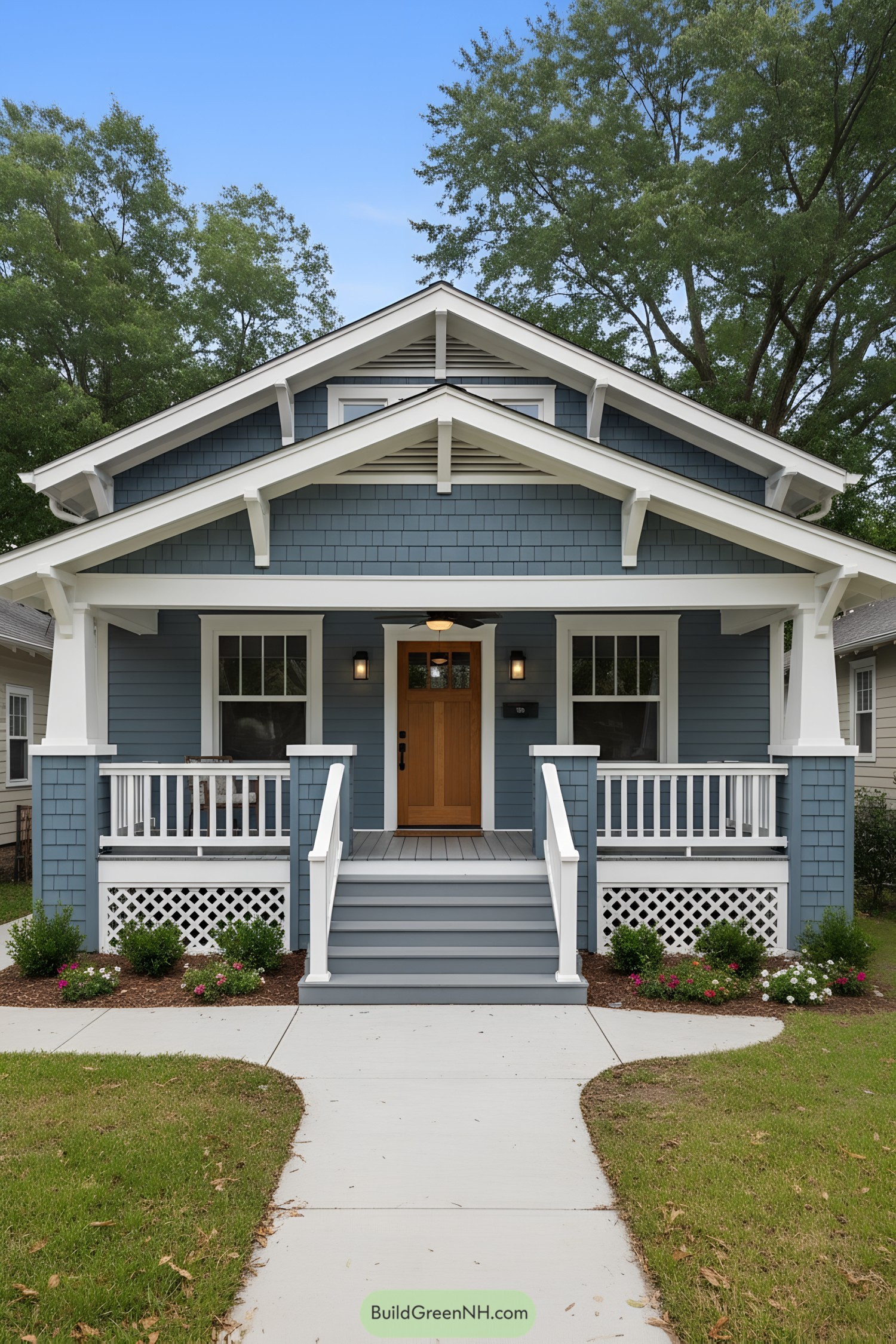 Blue shingle craftsman bungalow with white trim and a warm wood door