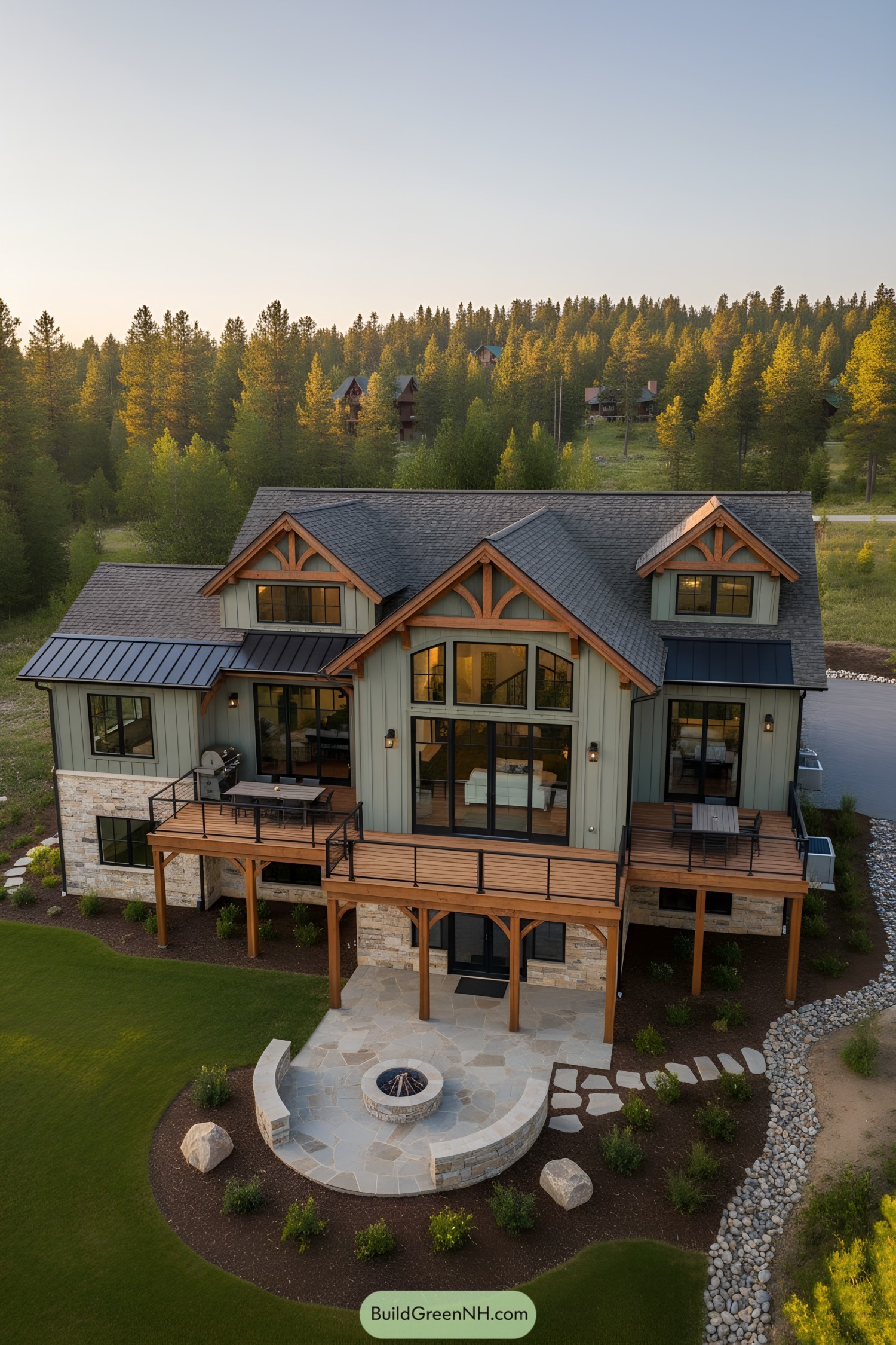 Two-story lodge with timber trusses stone base and wraparound deck overlooking a fire pit patio