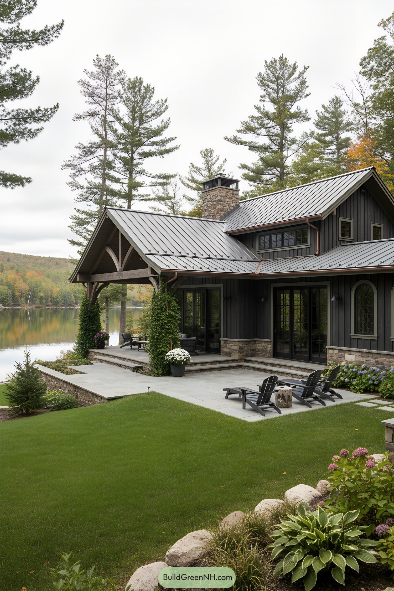 Dark timber lake house with metal roof, stone accents, and tiered patios