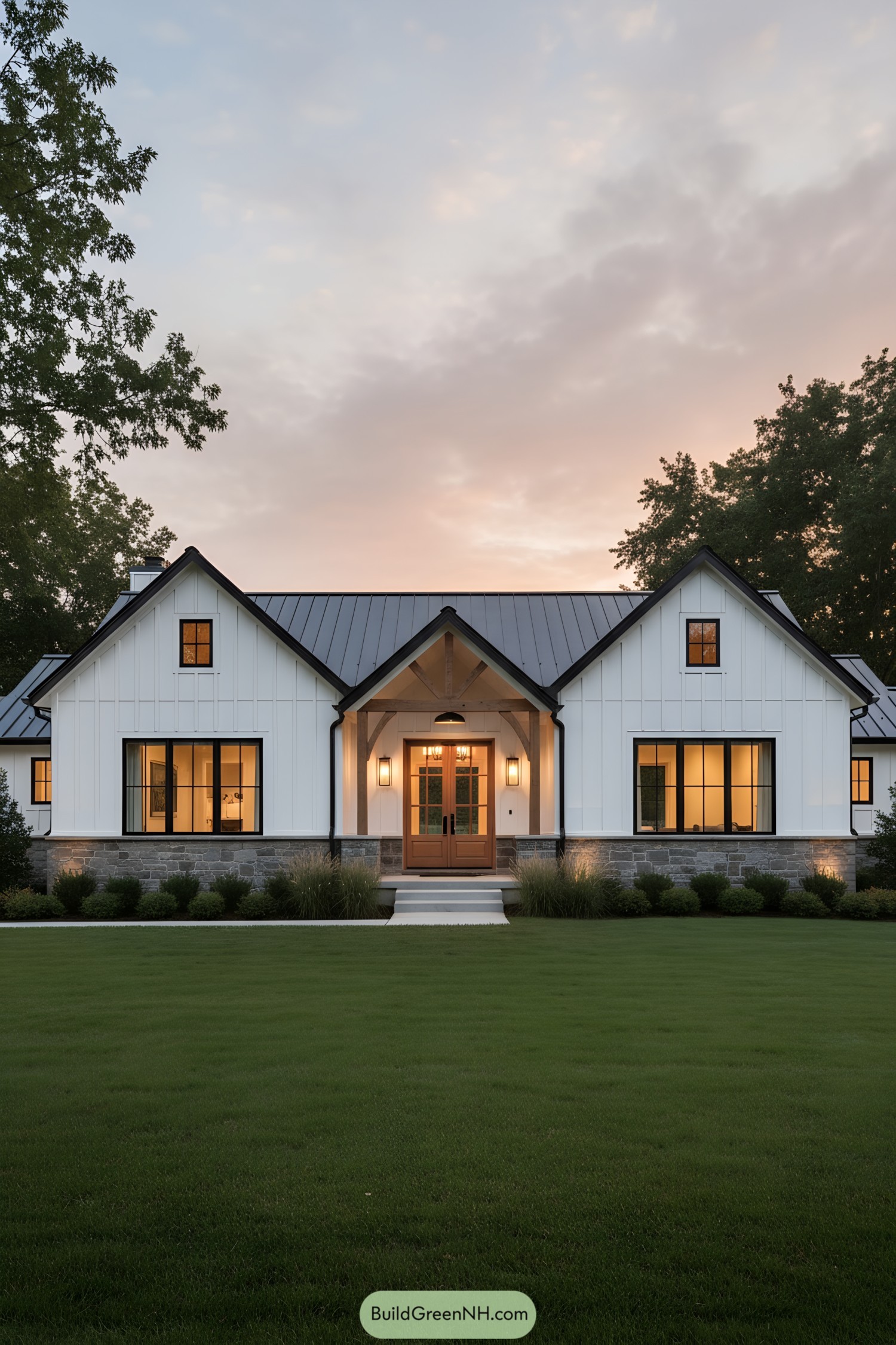White board-and-batten ranch with metal roof and warm wood entry glowing at dusk