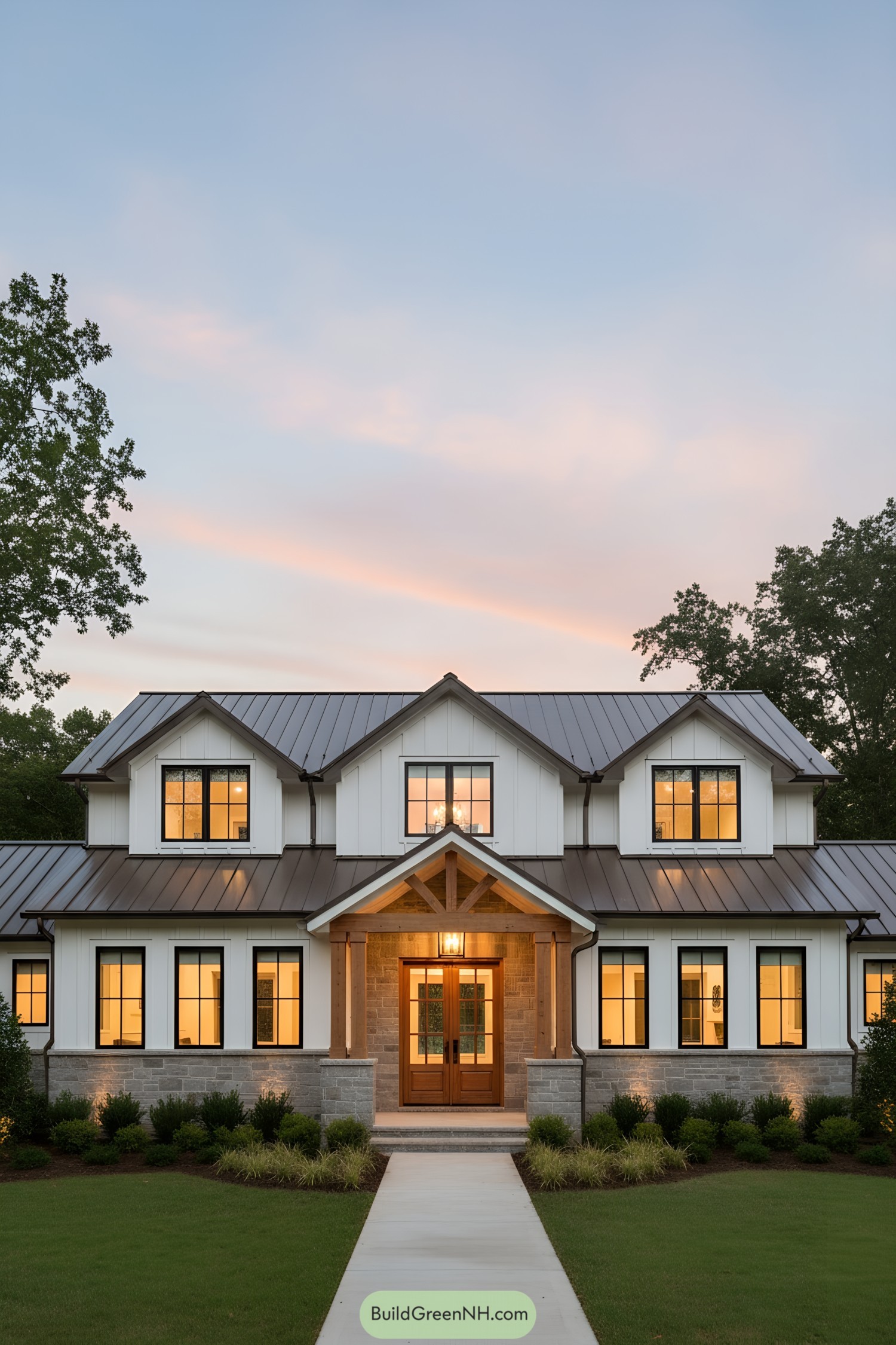 Warm-lit modern ranch with gabled porch and metal roof