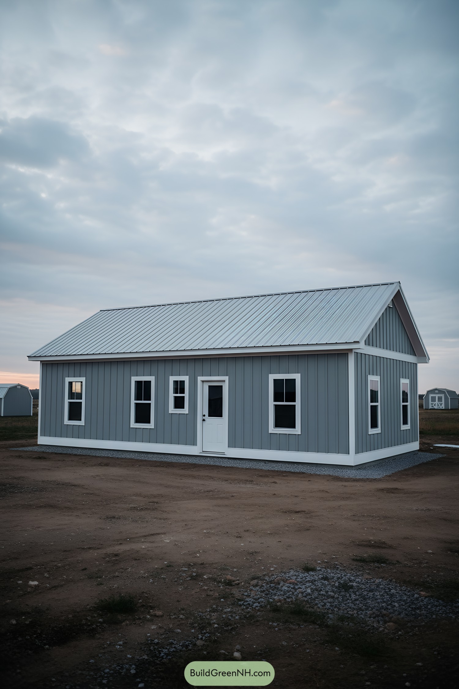 Gray shed house with white trim and metal gable roof