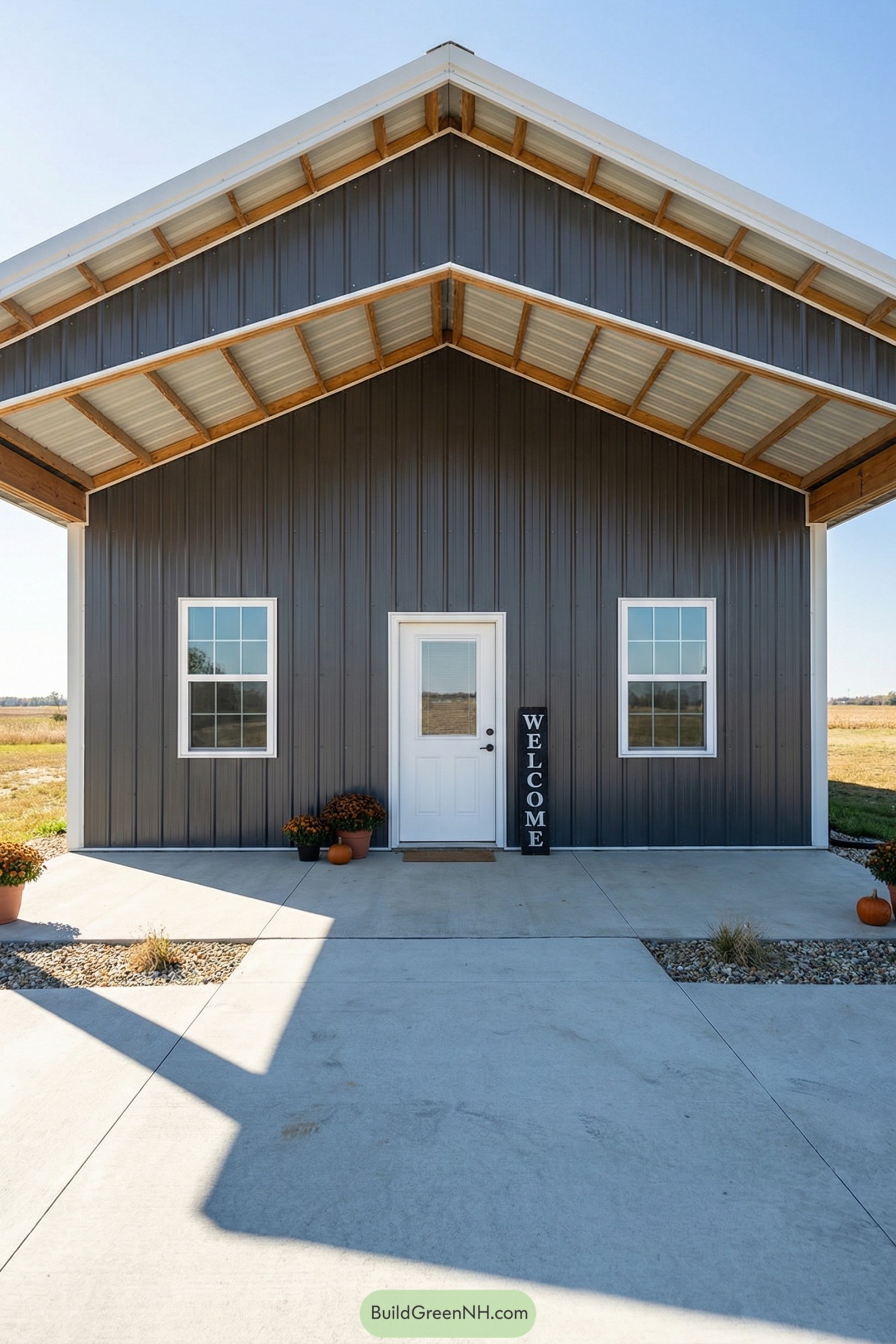 Front view of a dark metal barndo with deep gable porch and white door