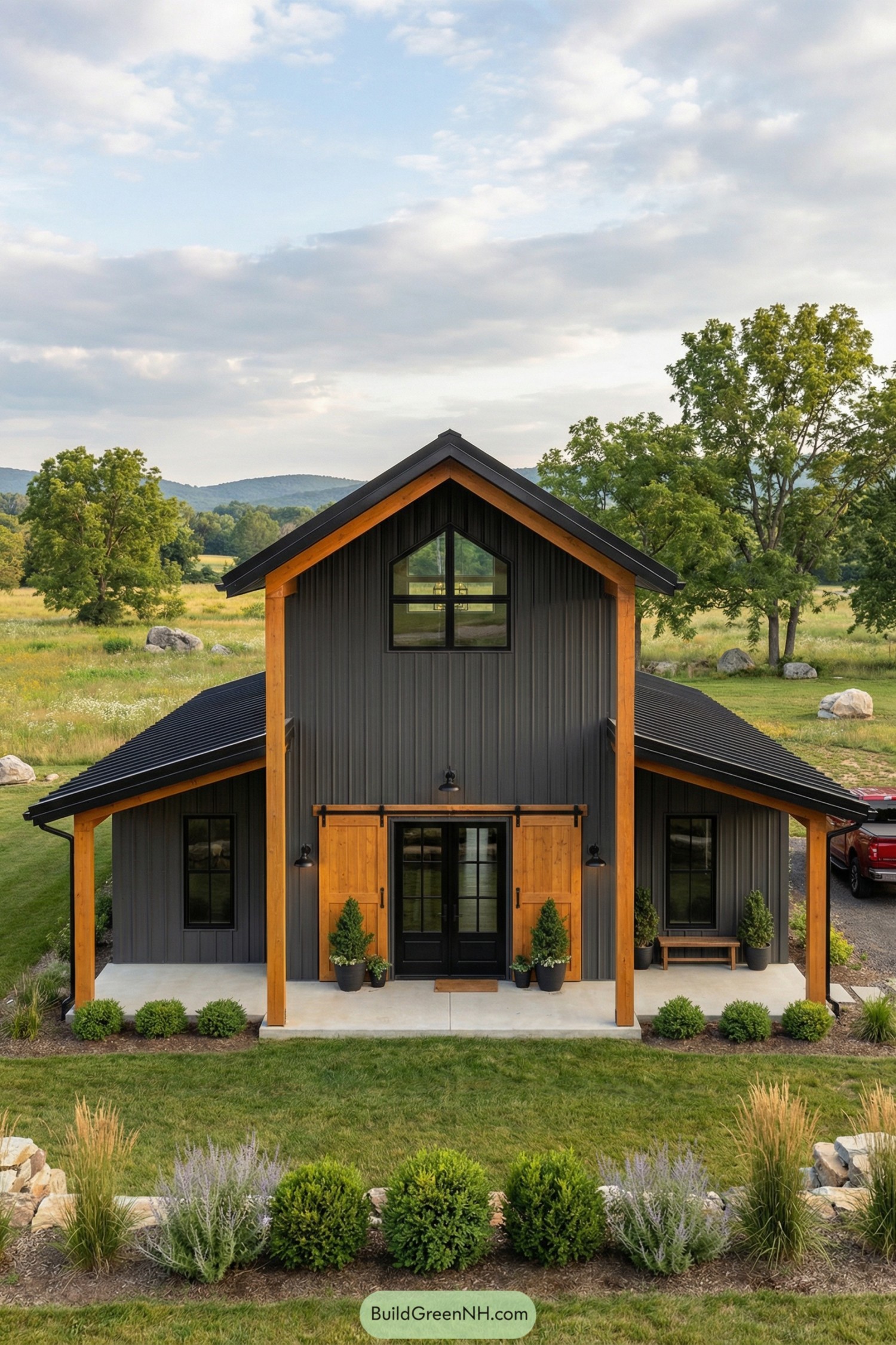 Dark metal barndominium with warm wood accents and centered gable entry