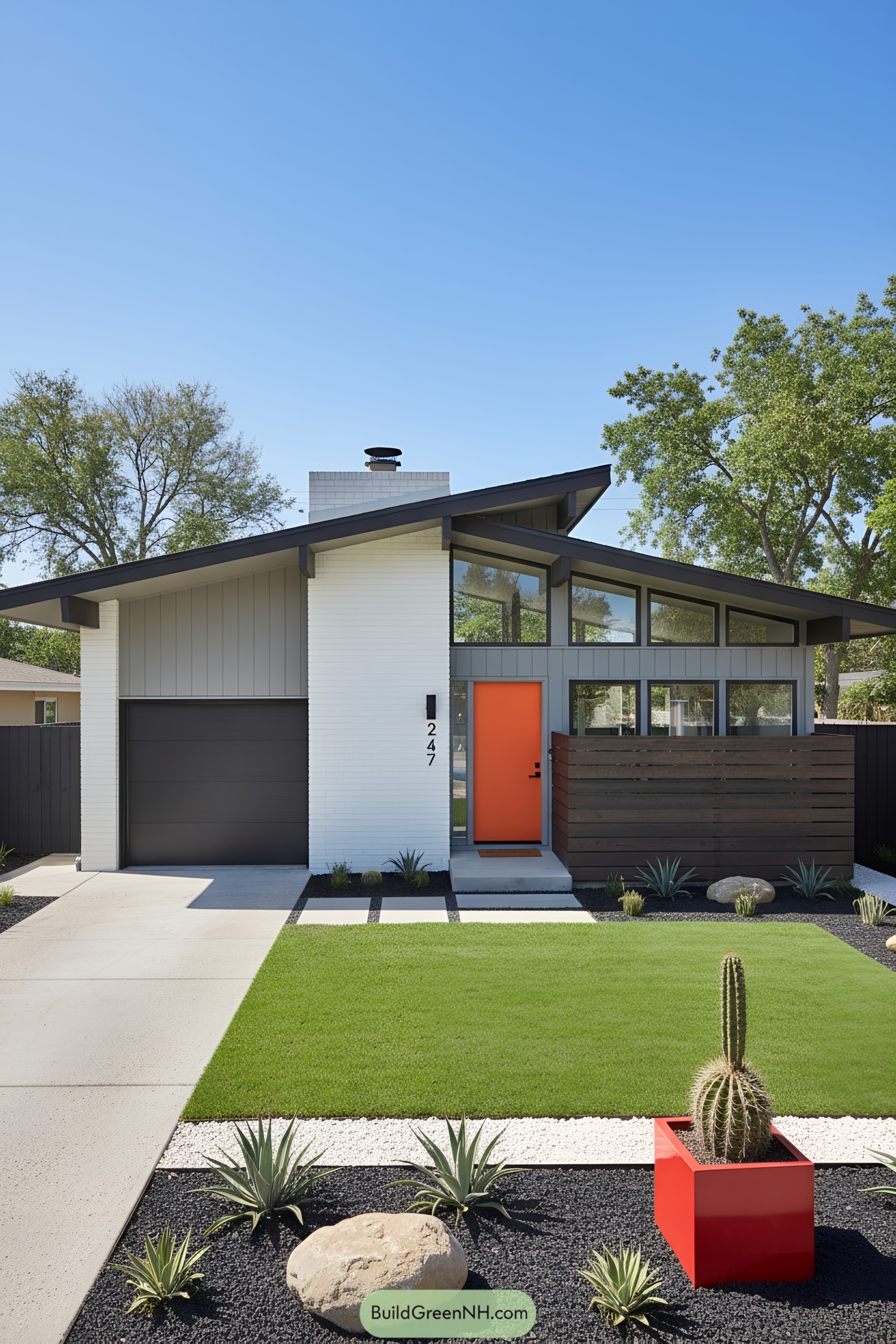 Mid-century house with angled roof, orange door, dark wood screen, and minimalist desert landscaping