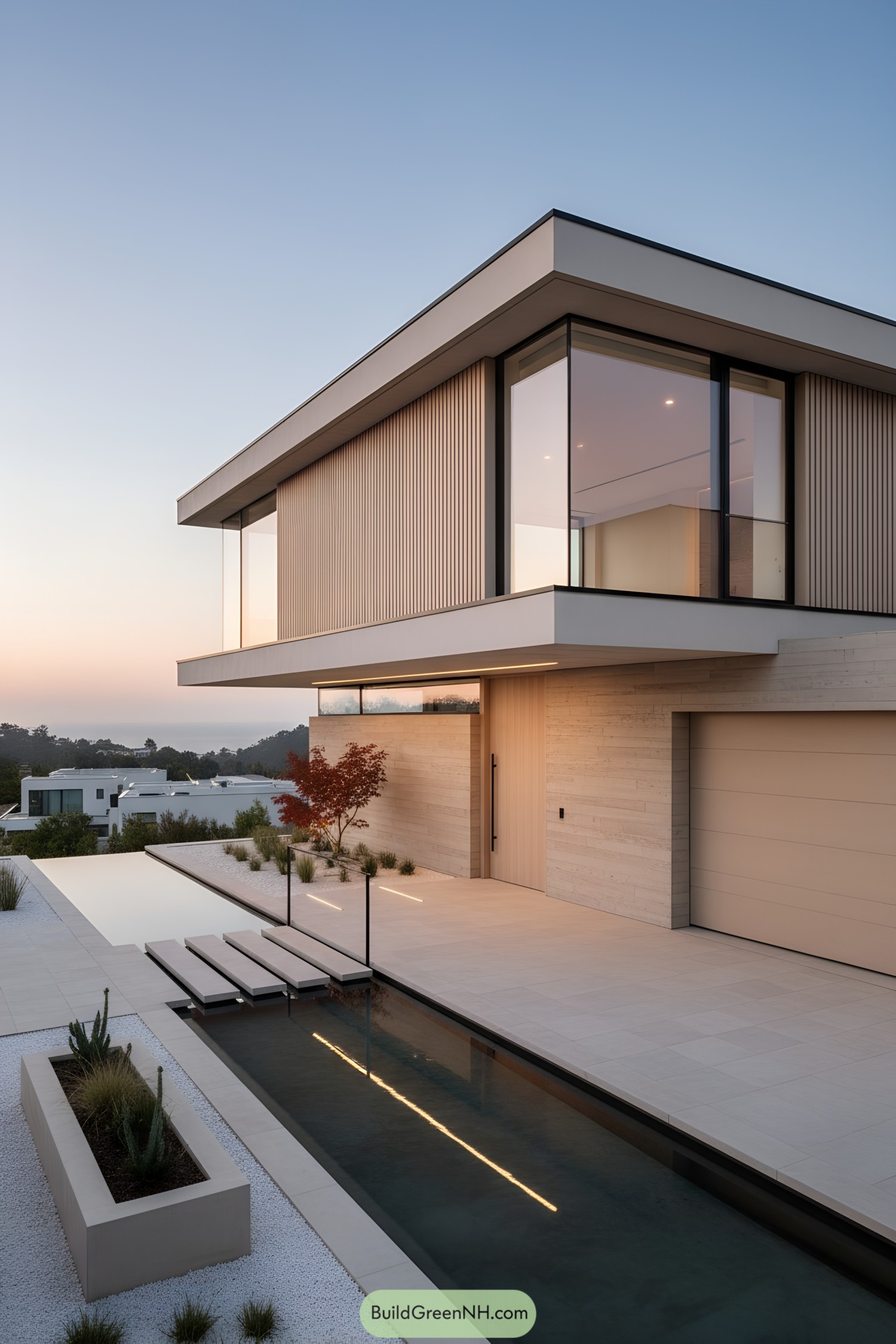 Minimalist two-story home with cantilevered upper level, floor-to-ceiling glass, and a narrow reflecting pool with stepping pads