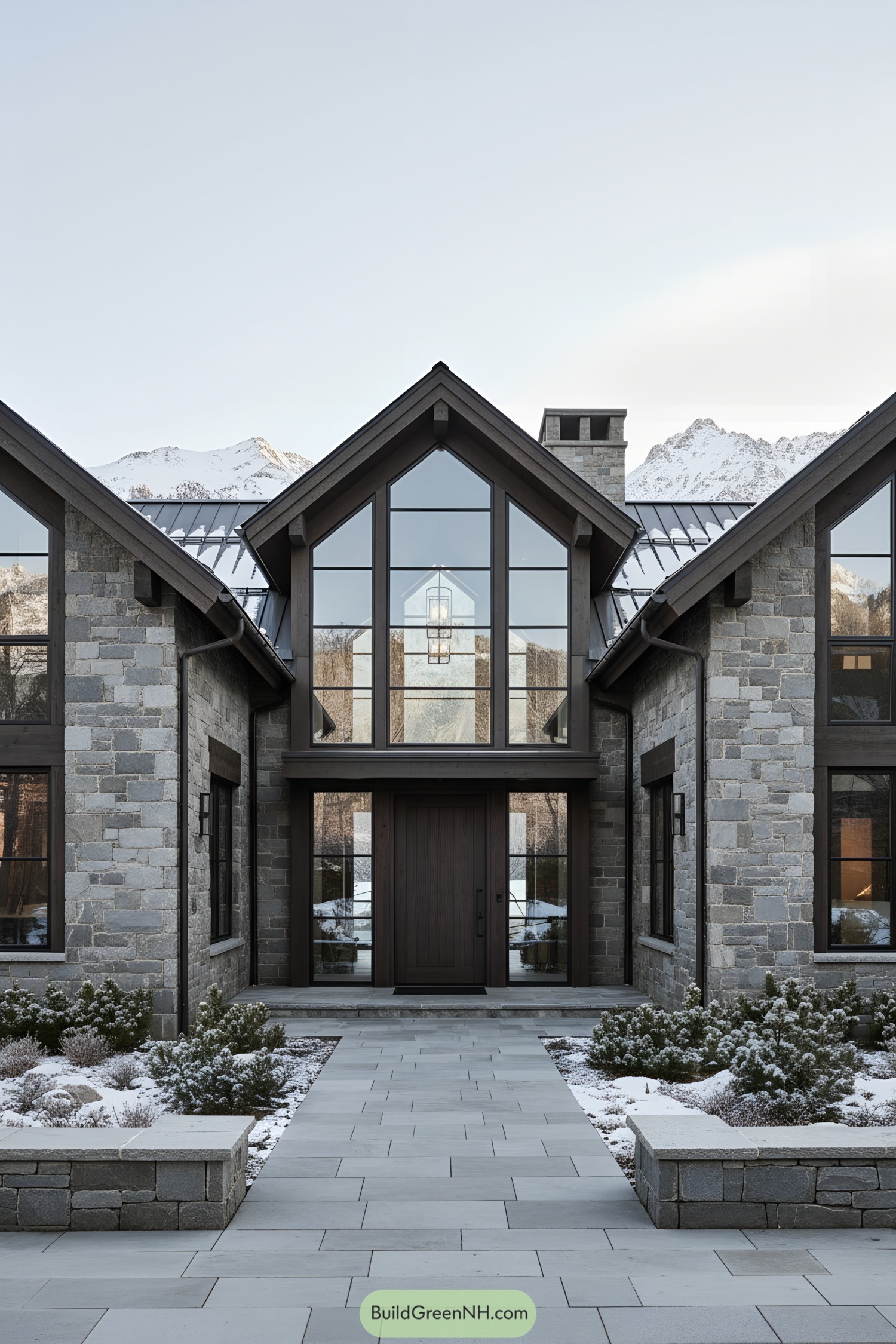 Stone-and-glass mountain home with central glass atrium entry