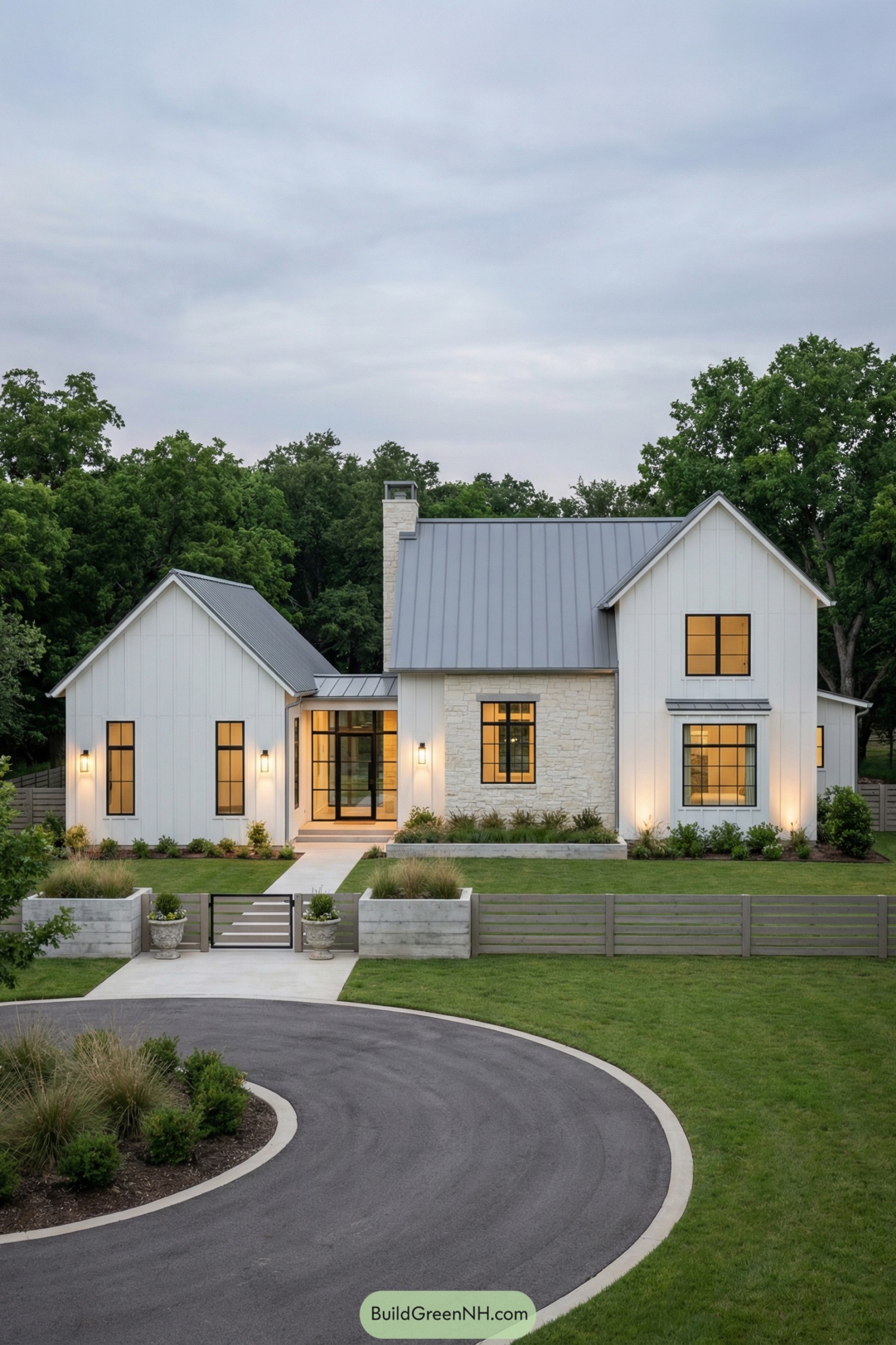 Modern white farmhouse with metal roof, stone accents, and large black-framed windows facing a circular driveway