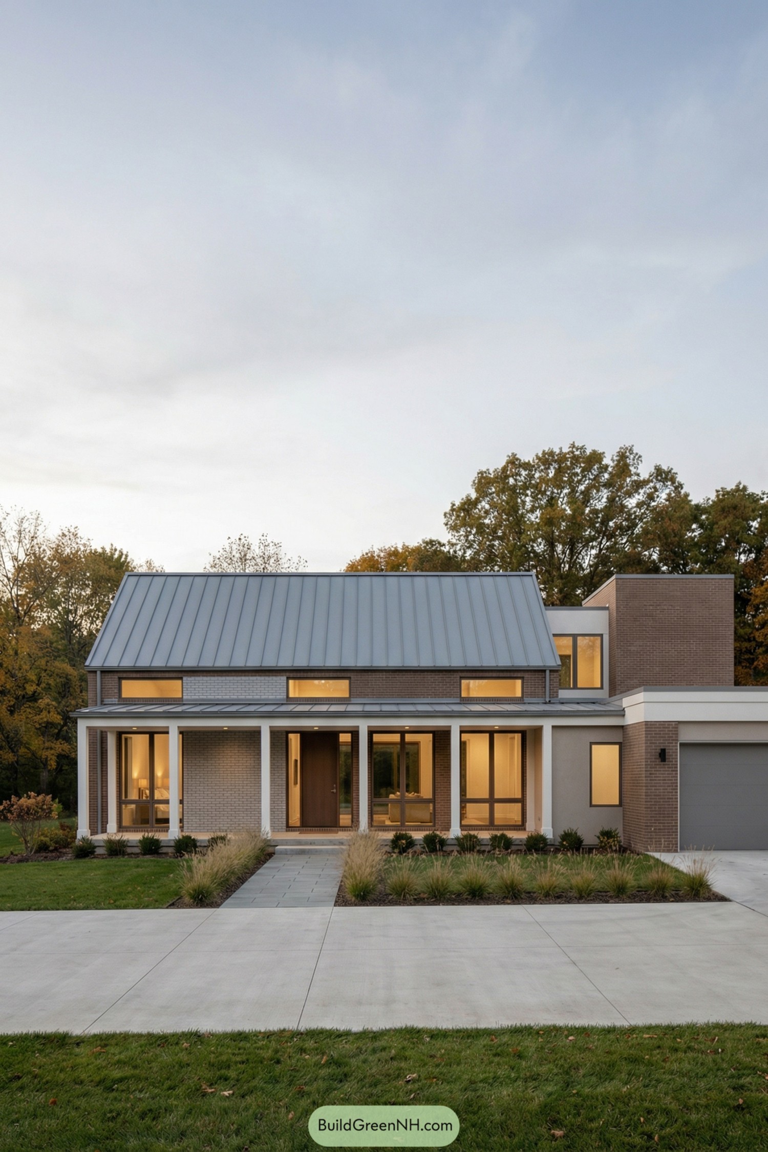 Modern brick farmhouse with metal roof at dusk