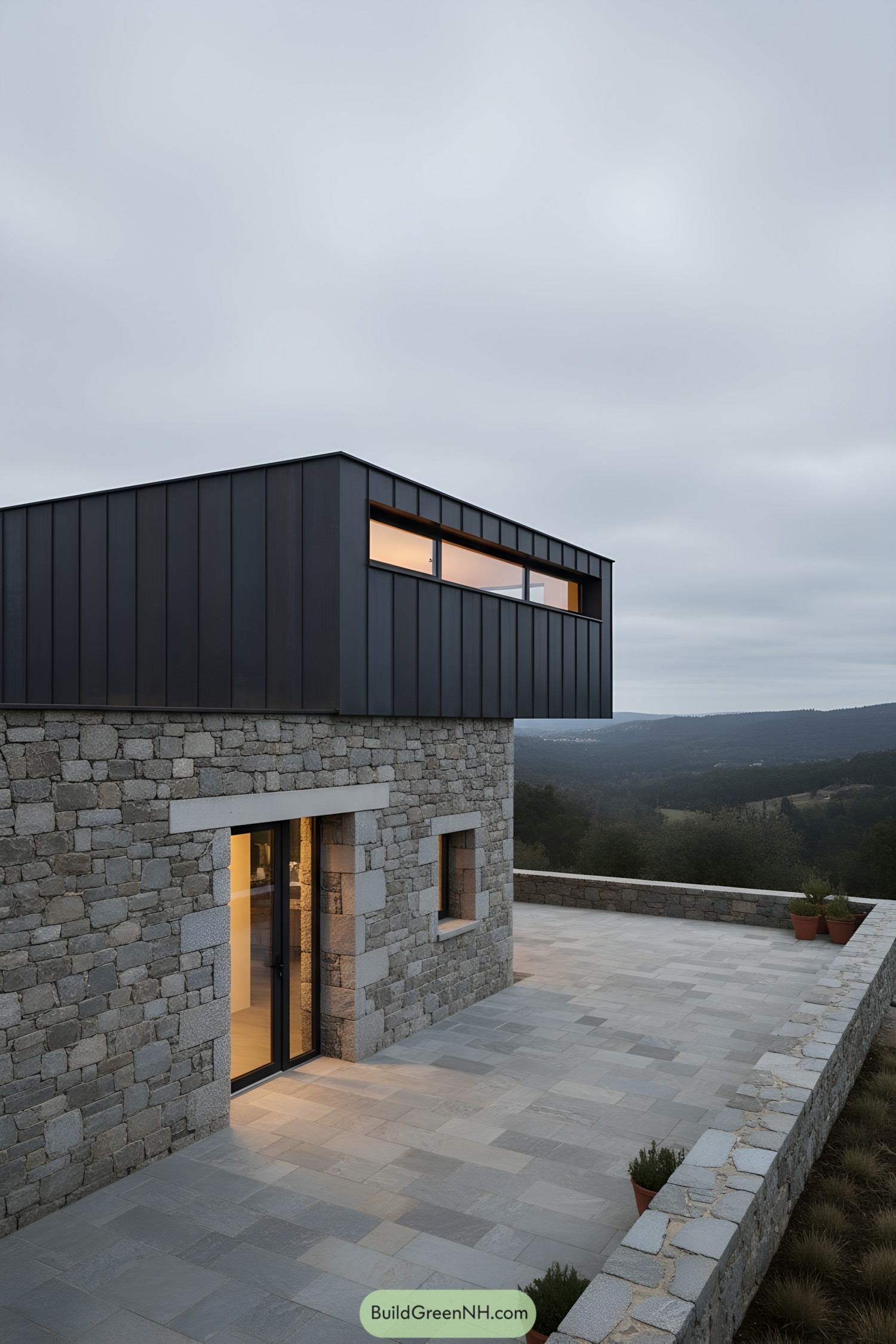 Modern stone cabin with dark metal upper volume and mountain-view terrace