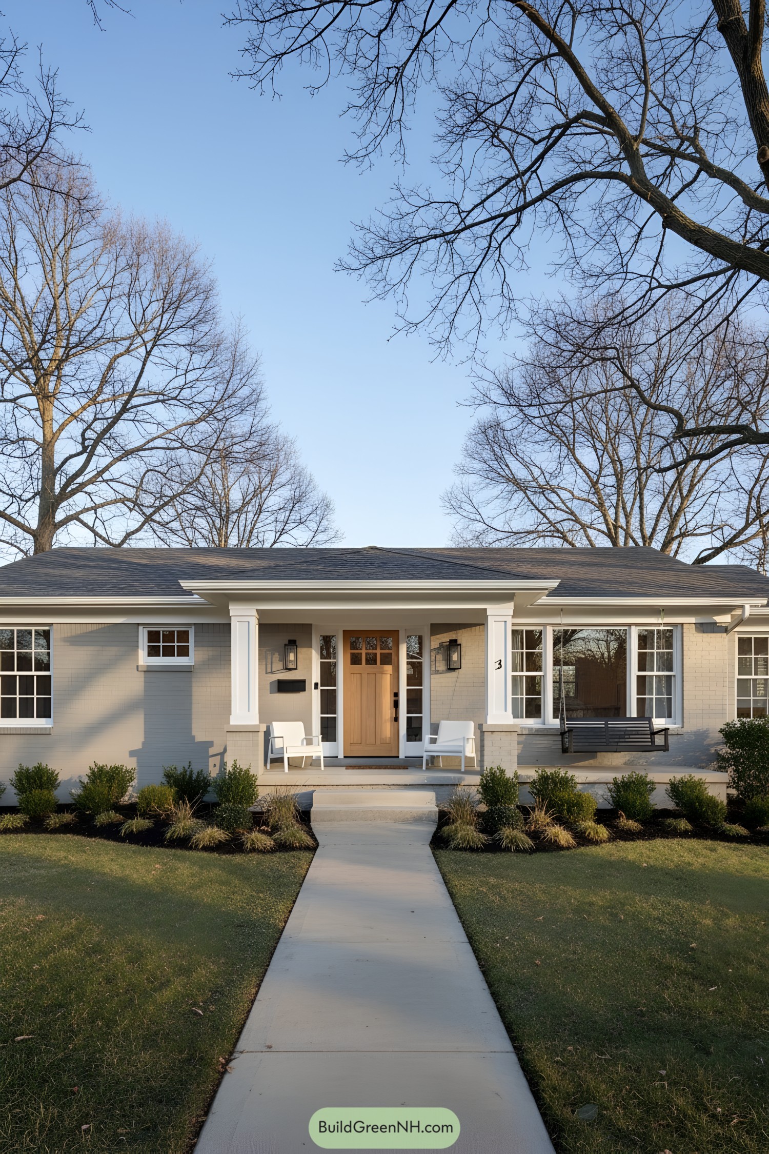 Neutral painted brick ranch with oak door, white trim, porch swing, and tidy landscaping