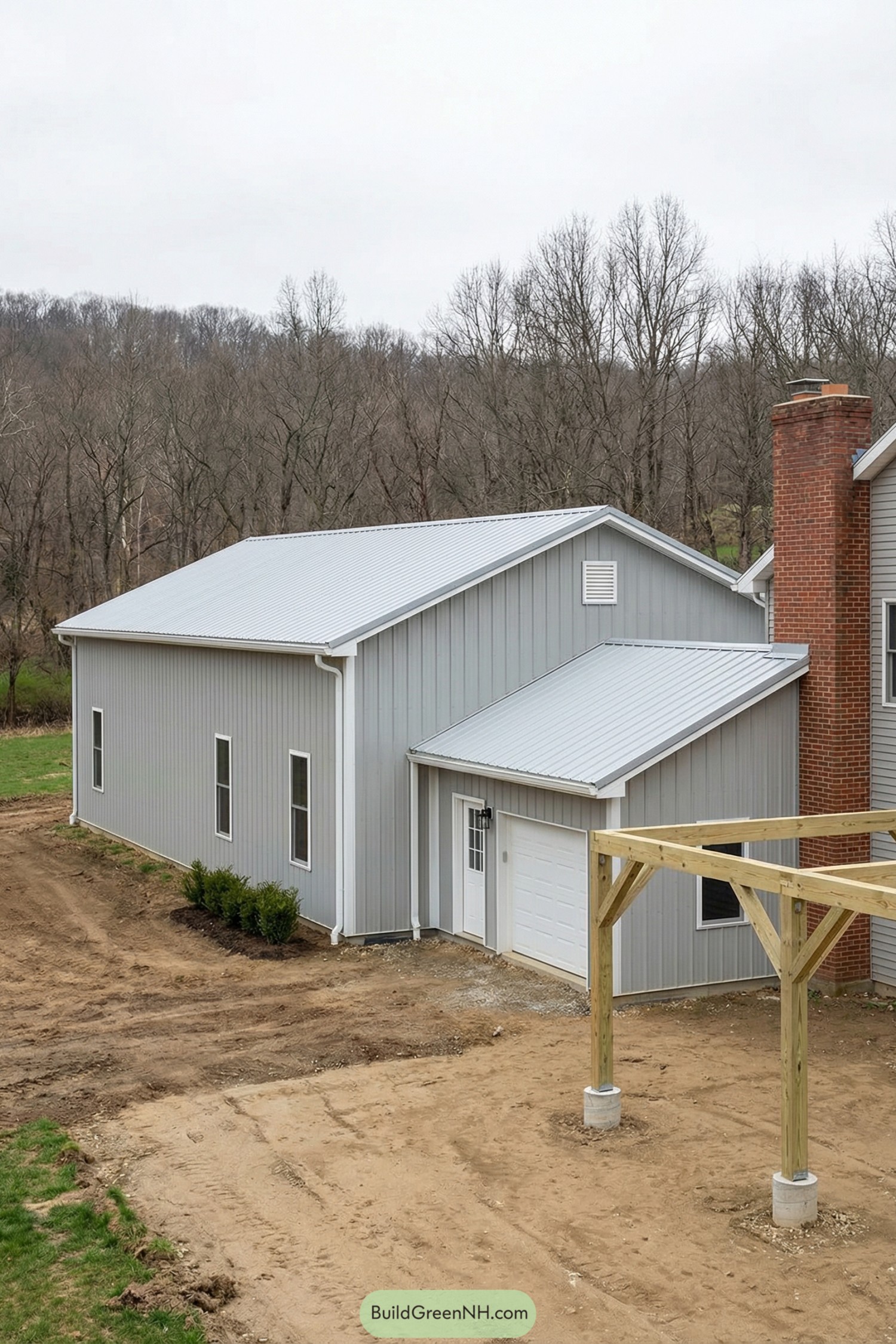 Gray metal barn home with attached single-bay garage and shed roofs