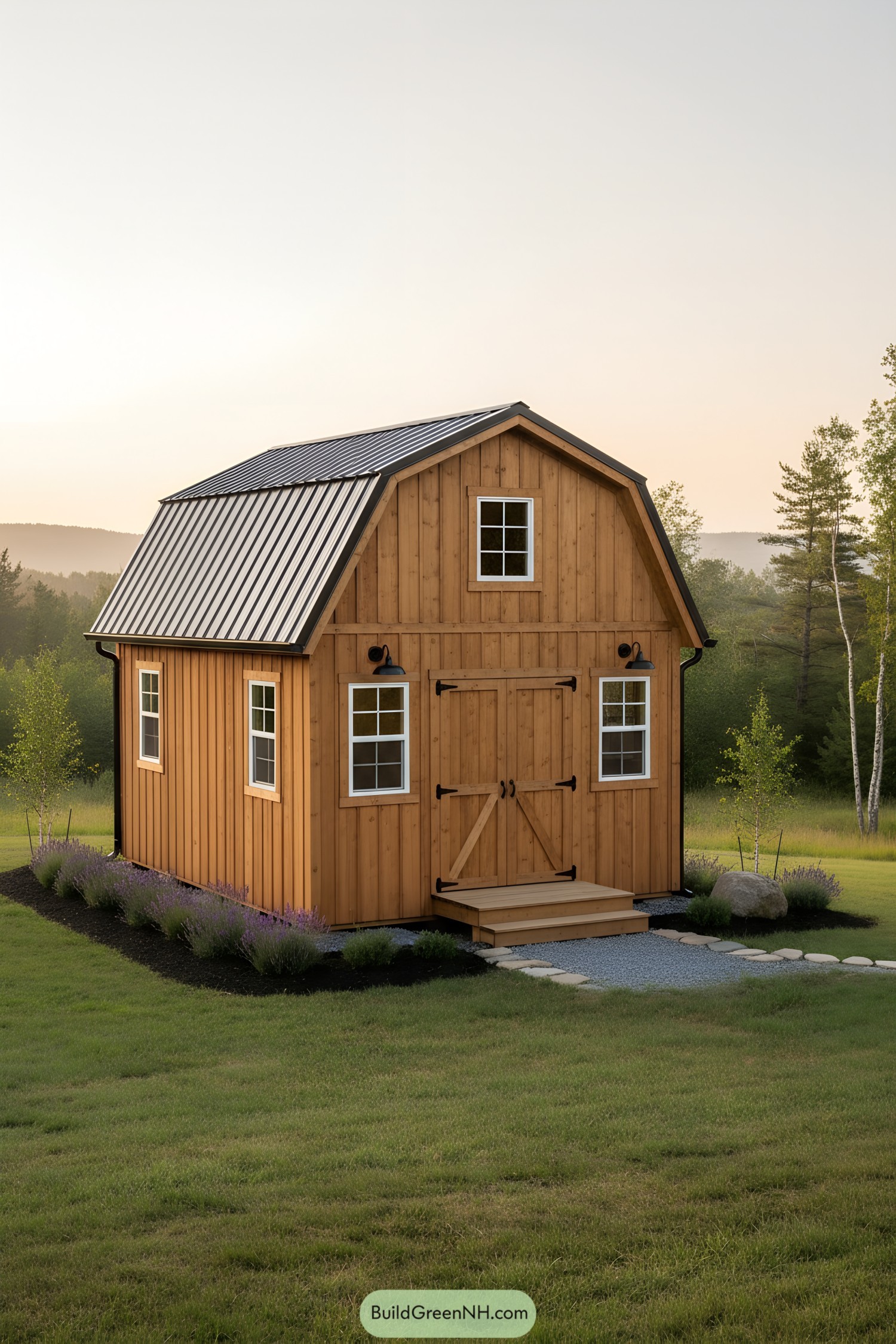 Small barn-style shed with loft and metal roof at sunset in a grassy field