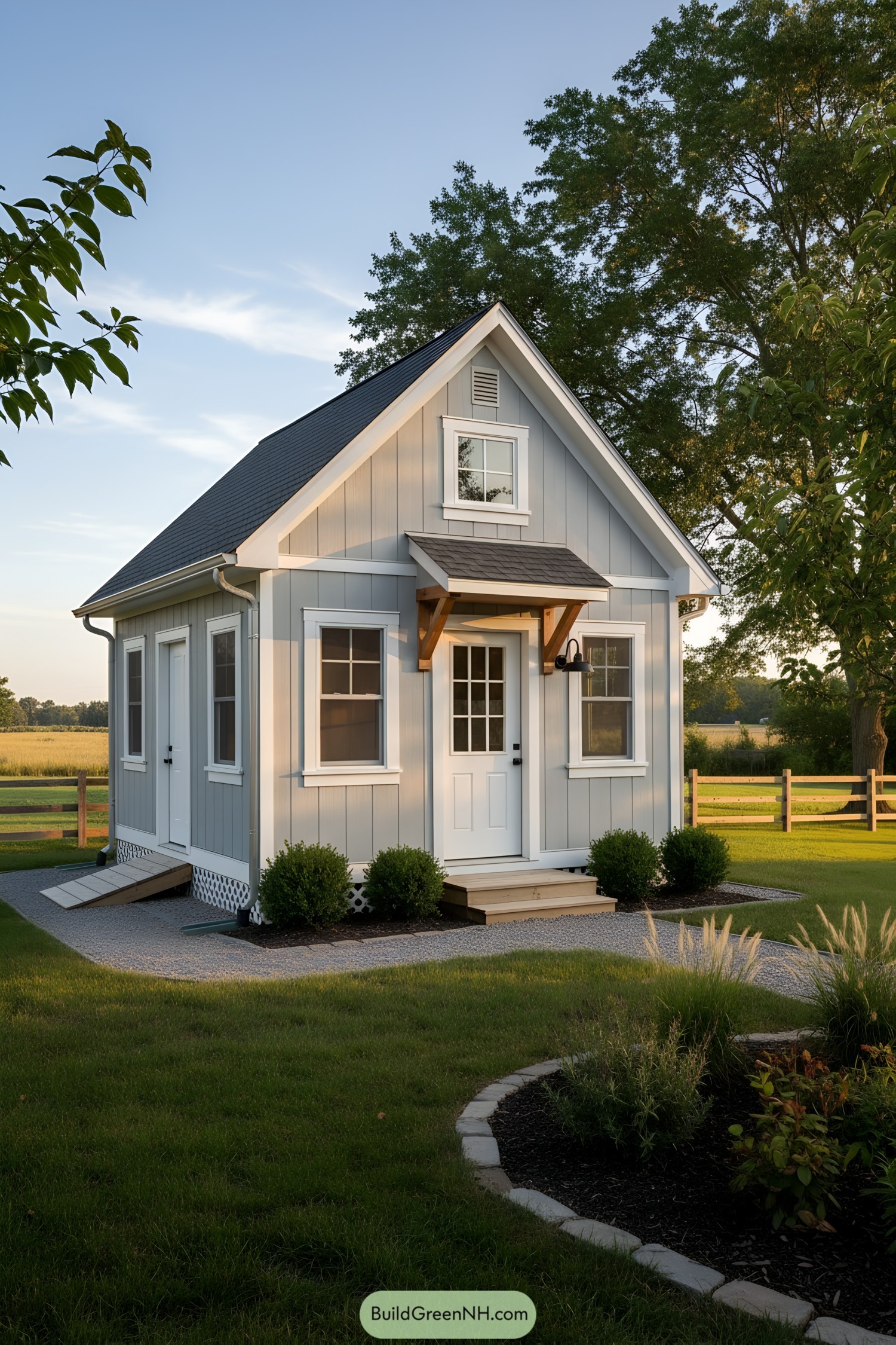 Small gray lofted shed with gable roof and porch awning