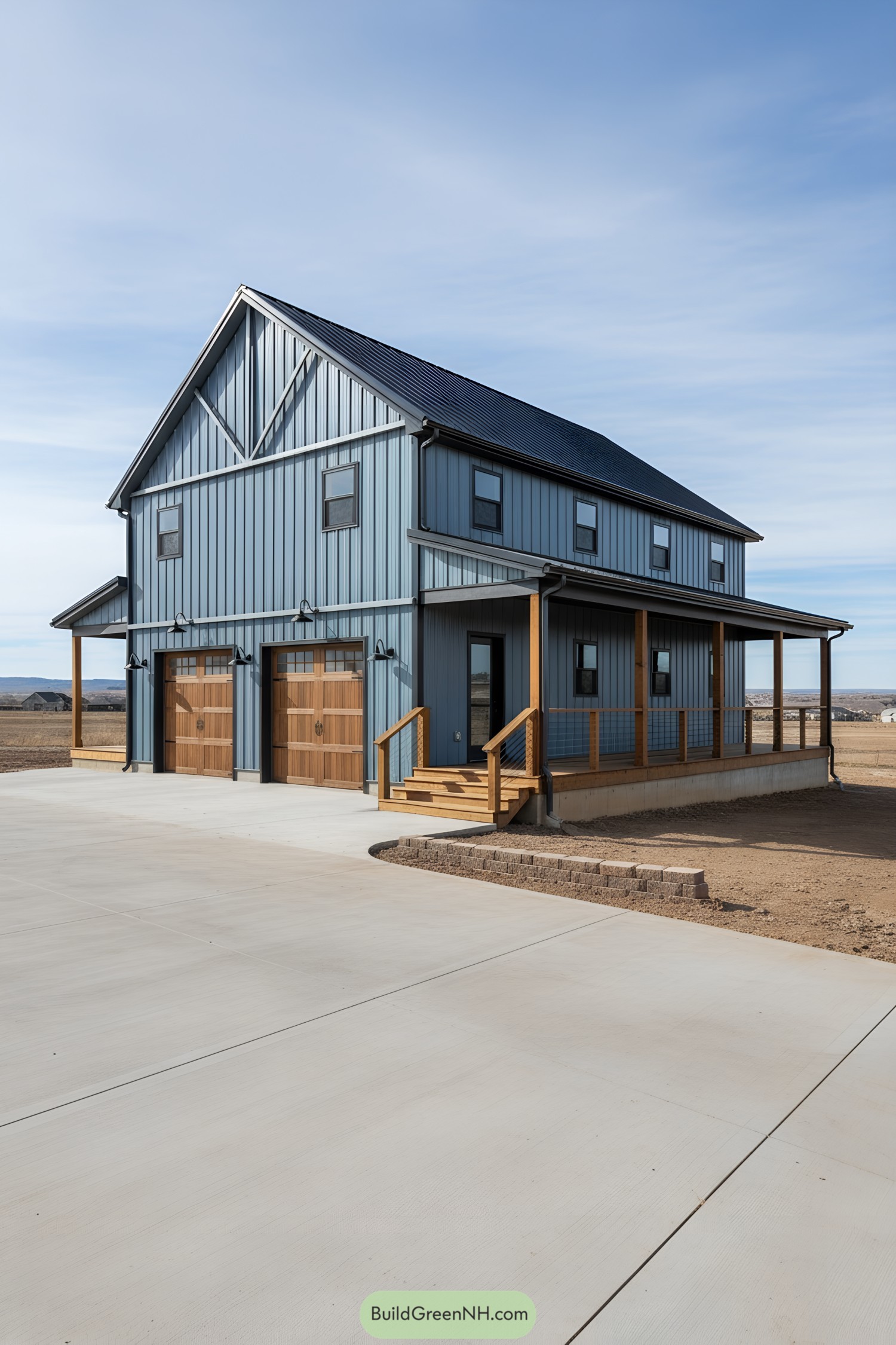Two-story blue steel barndominium with wraparound porch and twin timber garage doors