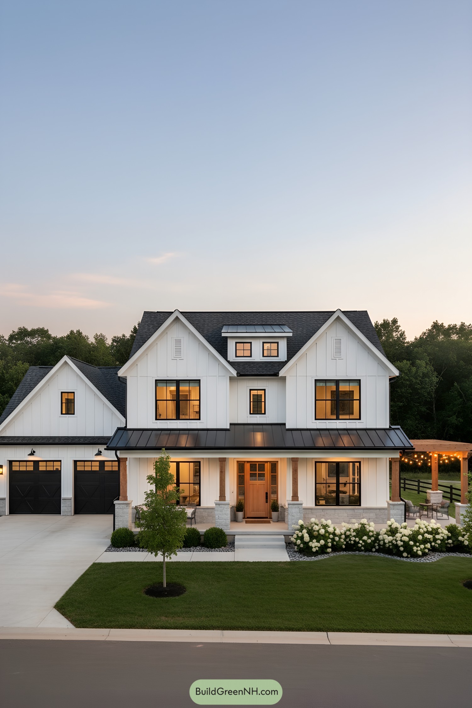 White farmhouse with black roof and warm lights
