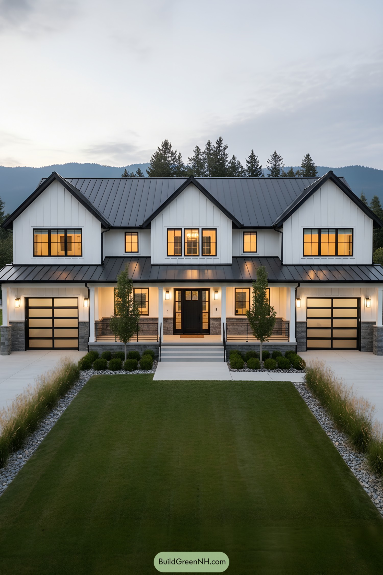 Two-story white farmhouse with black metal roof, twin glass garage doors, and glowing windows at dusk