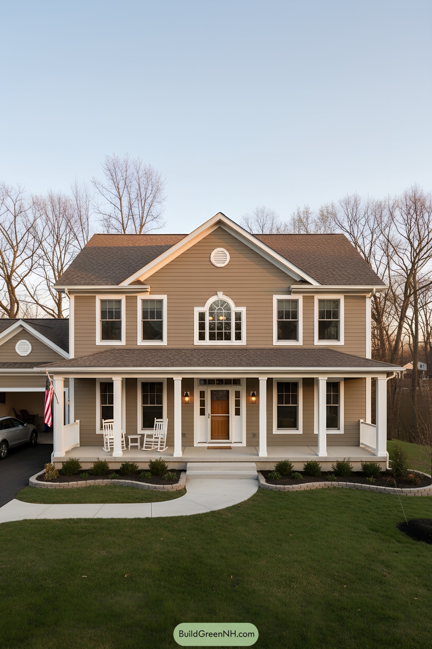 Two-story tan farmhouse with wraparound porch and gable roof
