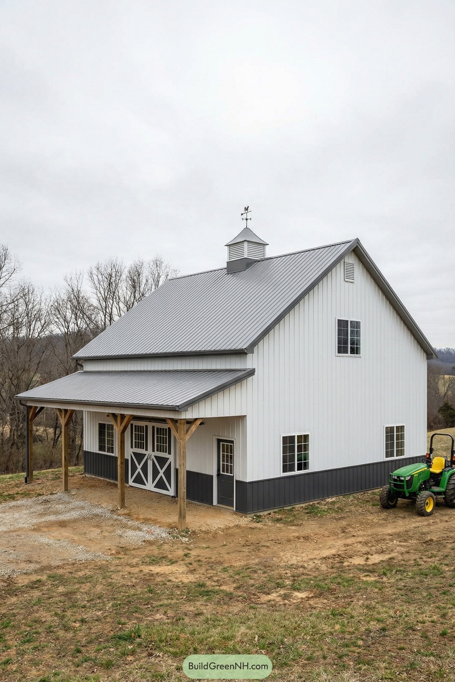 White pole barn with gray metal roof, cupola, timber porch posts, and dark wainscot
