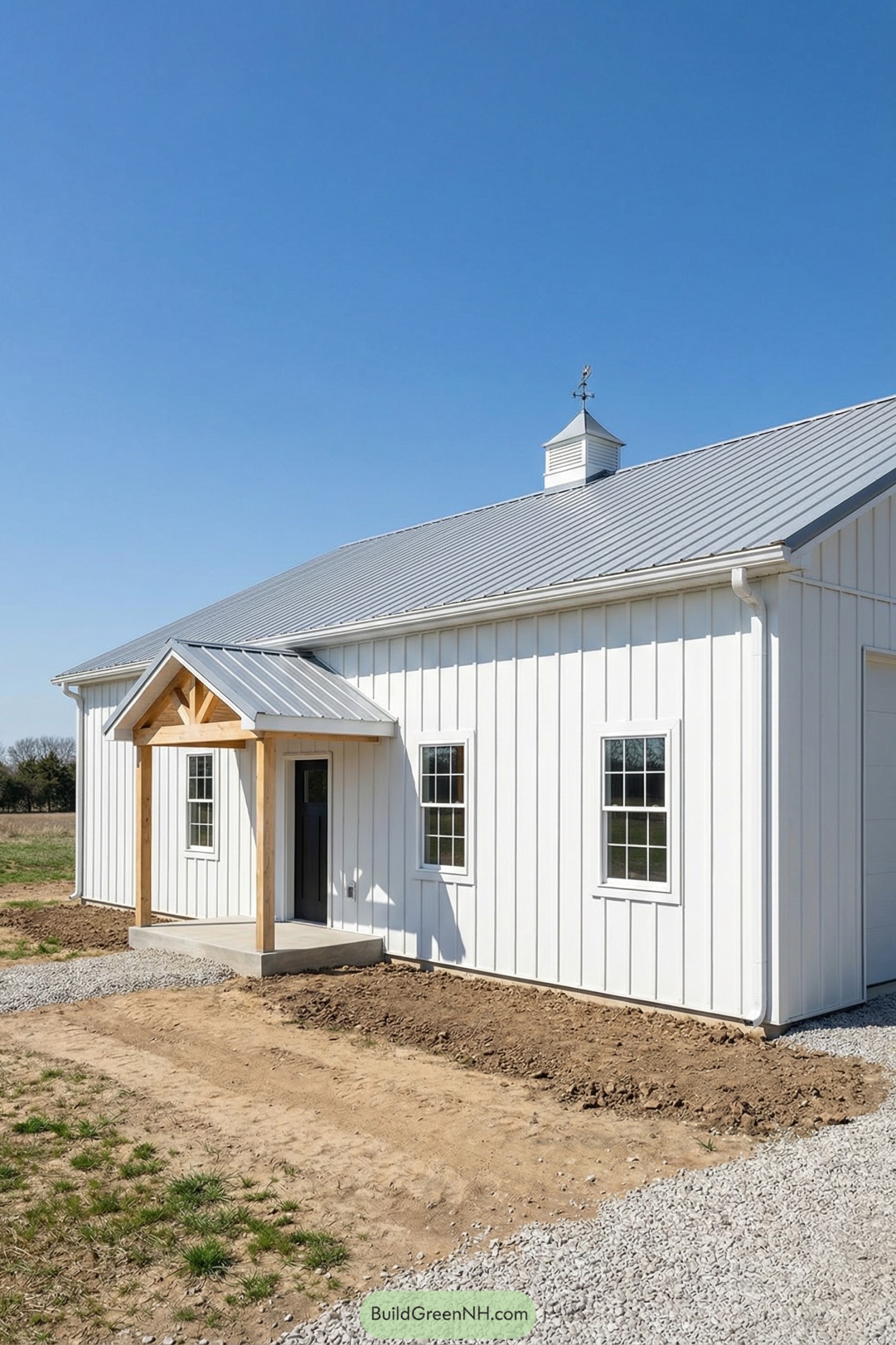 White pole barn with metal roof and small timber entry porch