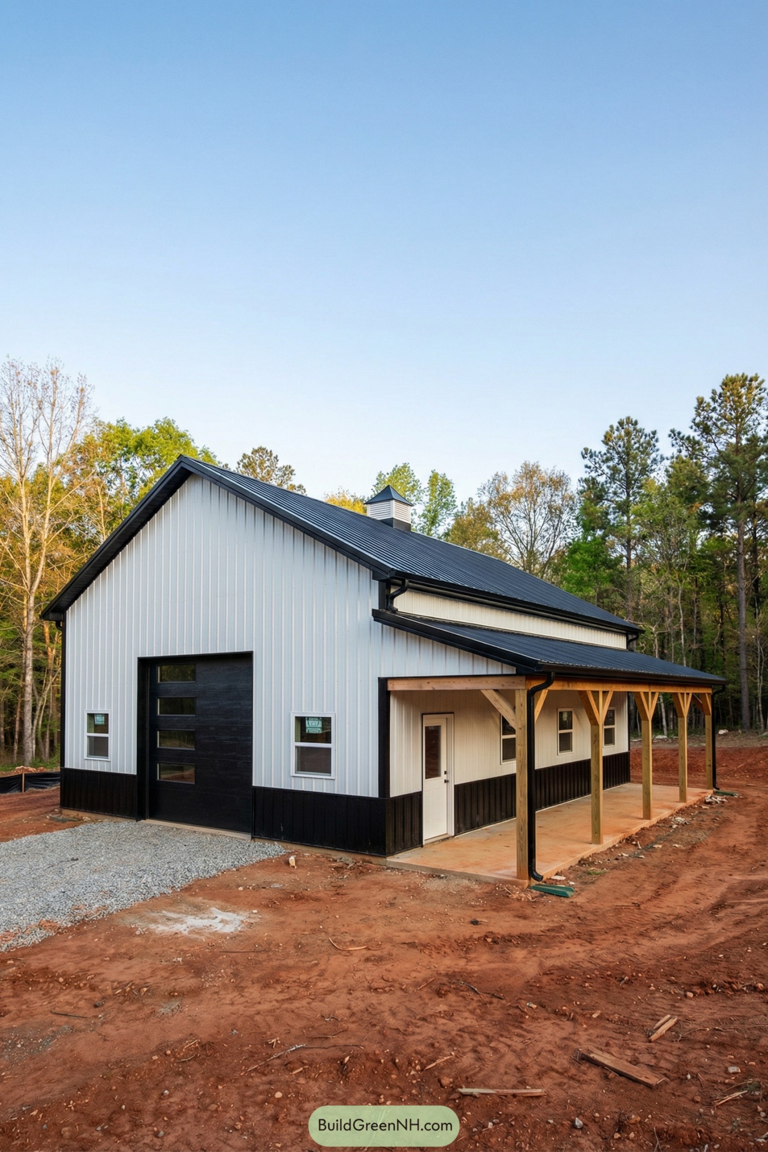 White pole barn with black roof and wainscot, shed-roof porch, and timber posts