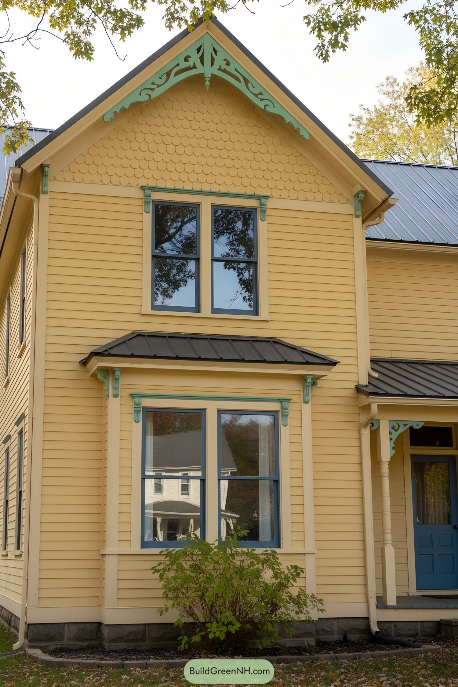 Yellow clapboard house with teal trim and decorative gable