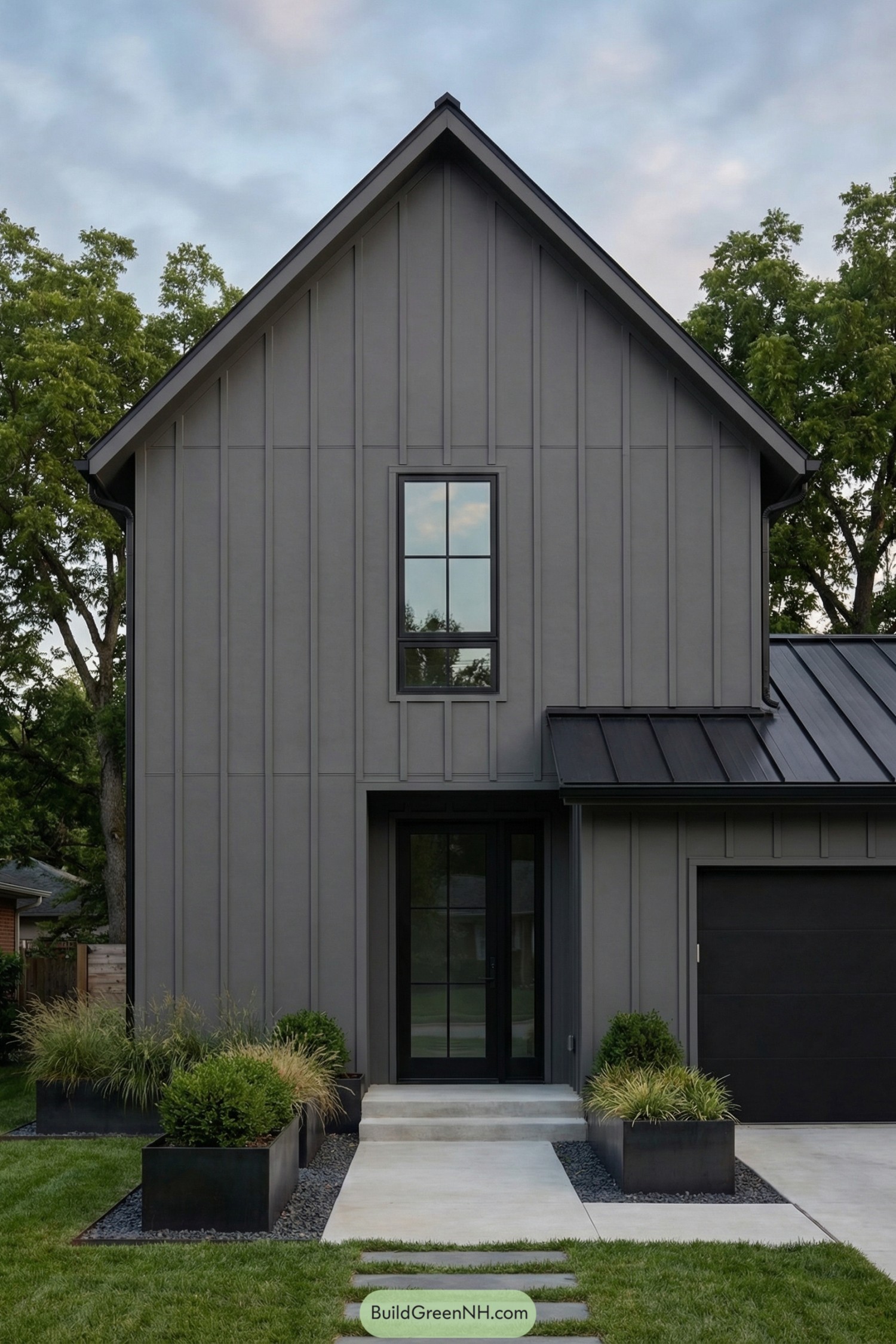 Dark gray modern farmhouse with tall gable front door and simple landscaped entry path
