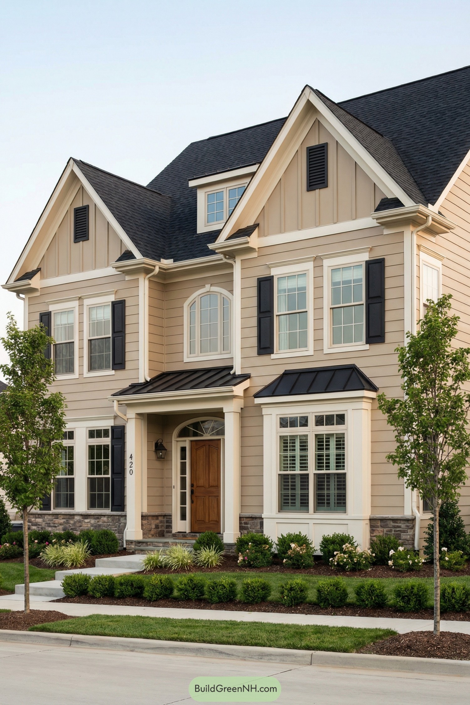 Two-story beige house with dark roof, white trim, and manicured front yard