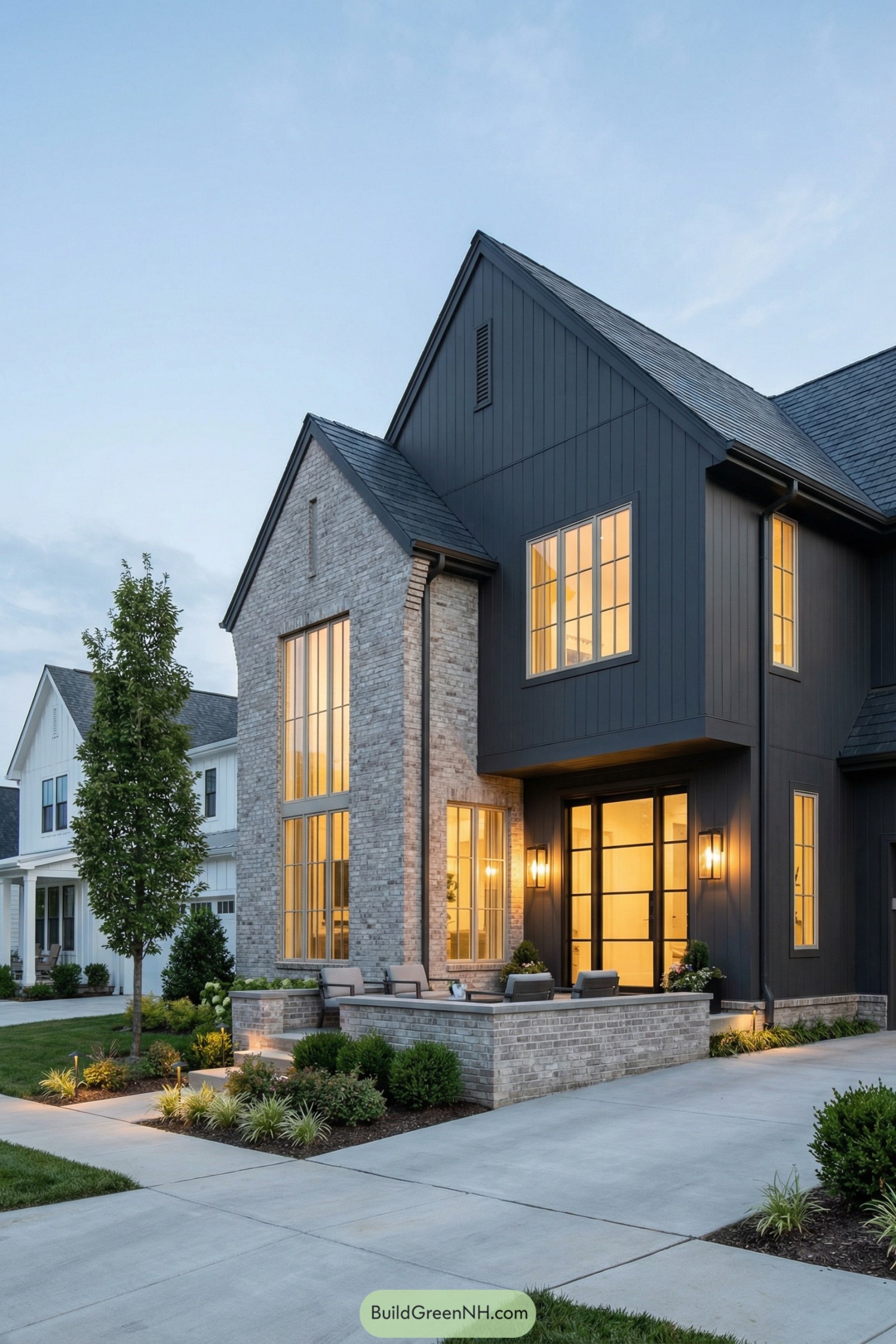 Modern dark gabled home with tall glowing windows