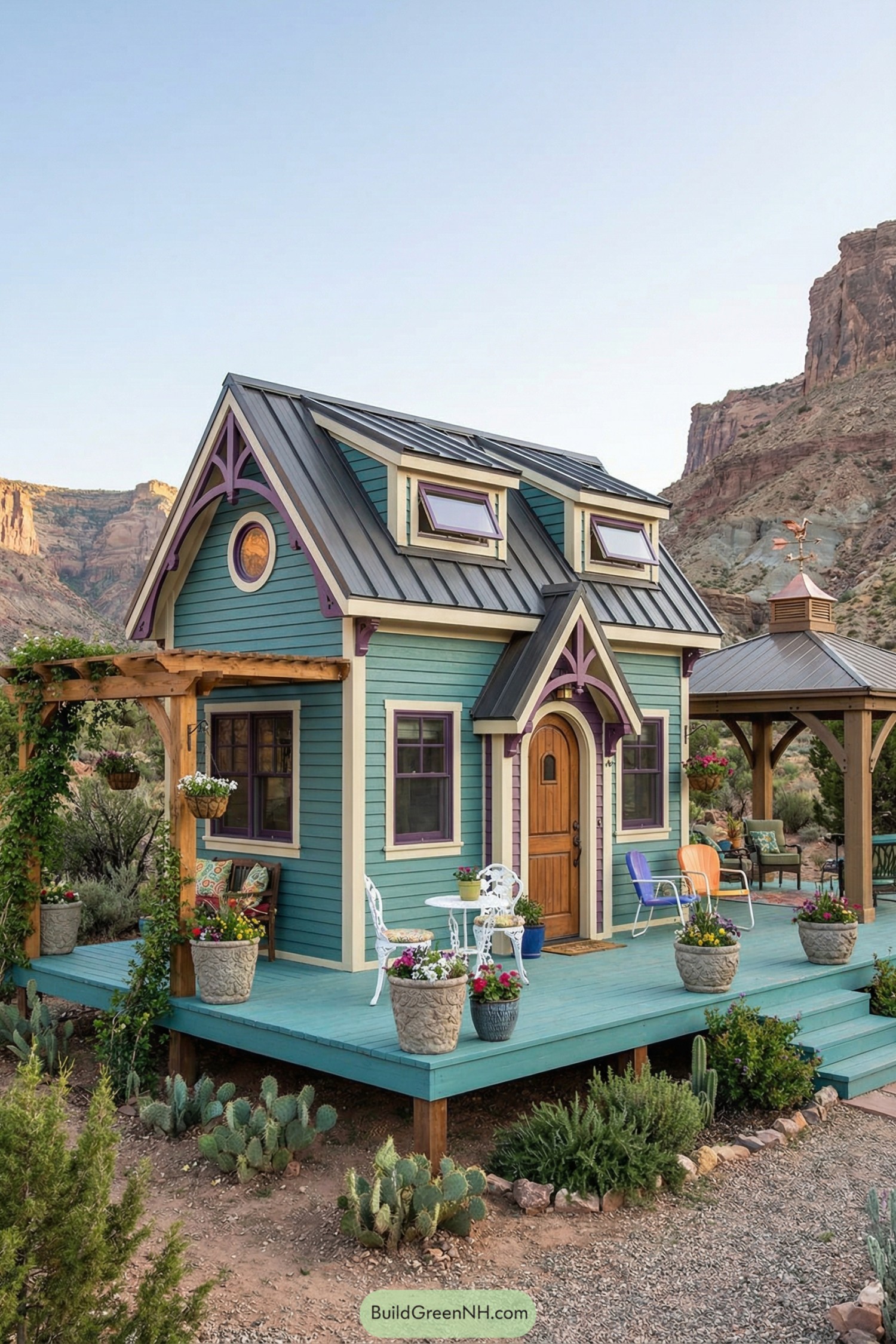 Colorful tiny house with teal siding and purple trim on a raised deck in a rocky desert landscape