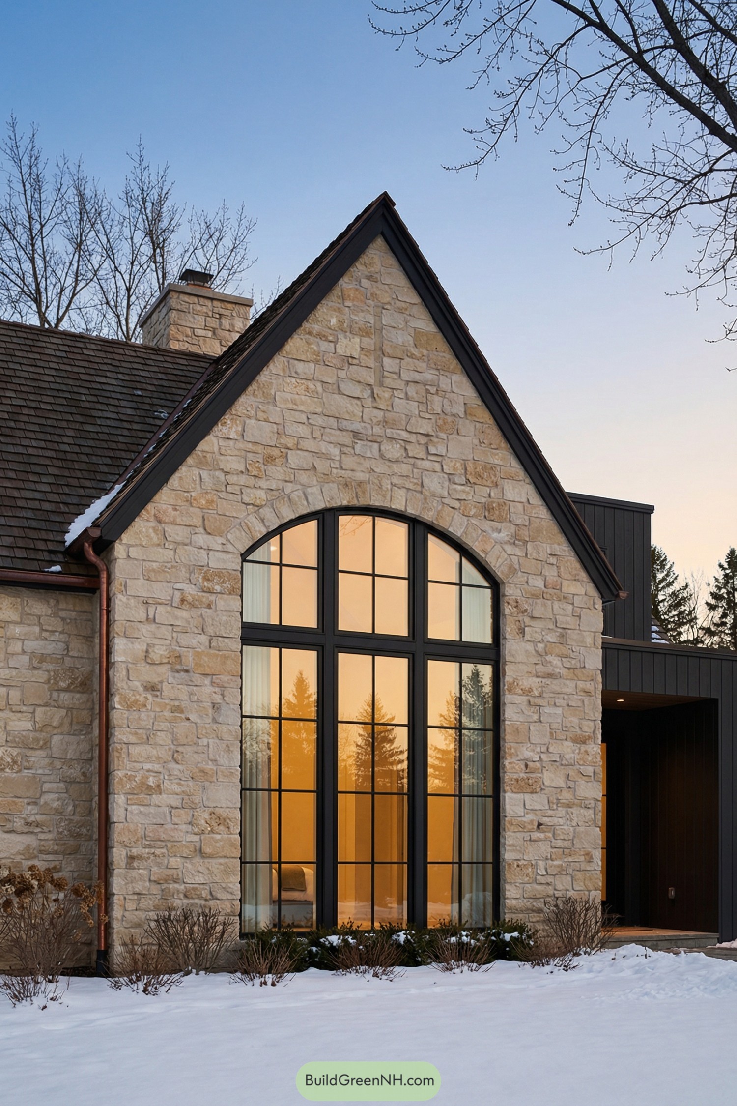 Stone house with tall arched window at dusk