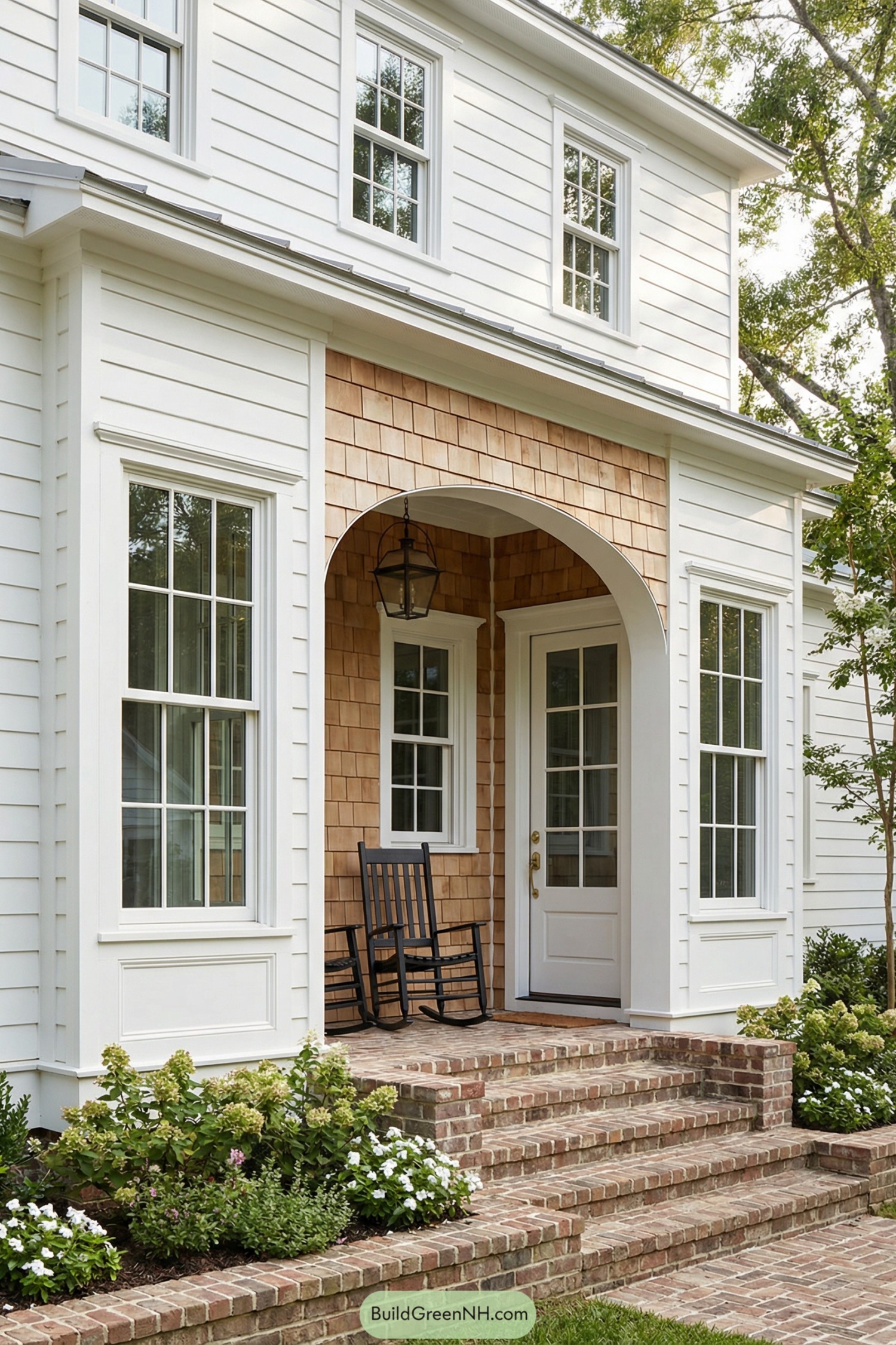 White shiplap house entry with brick steps and cedar shingle alcove