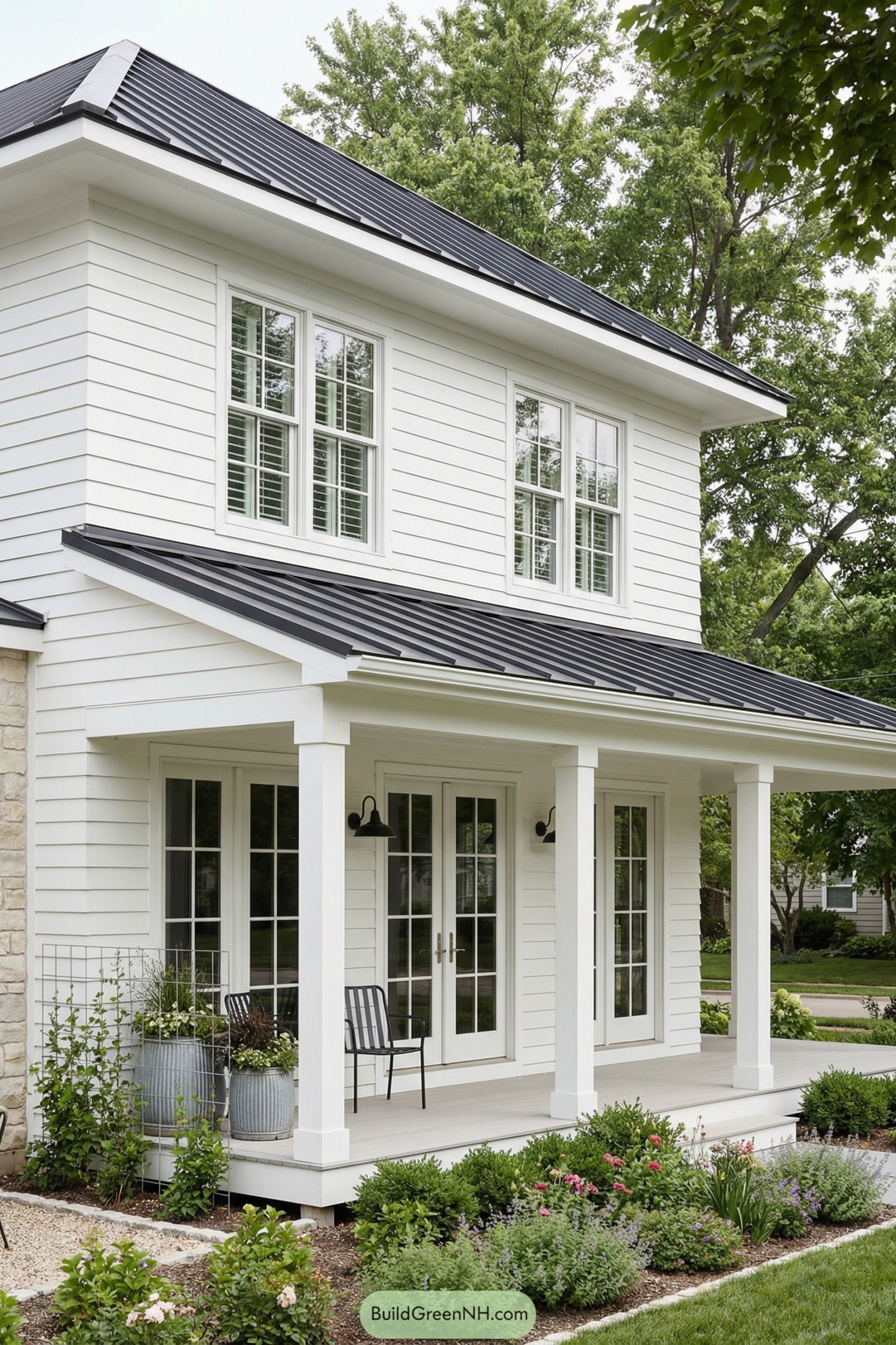 White shiplap house with black metal roof and simple front porch