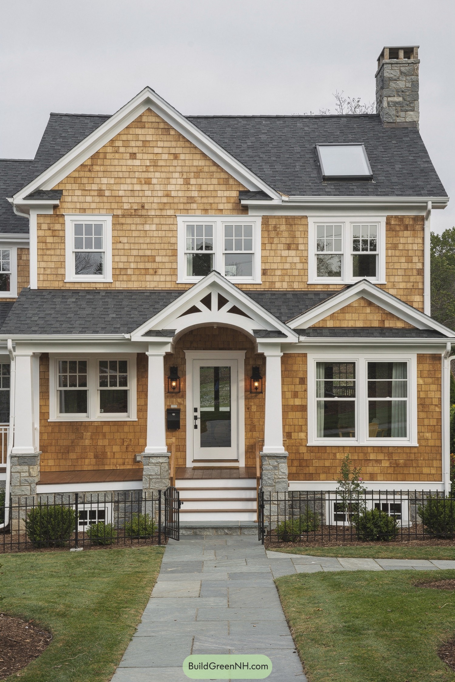 Front view of cedar shingle house with white trim and stone accents