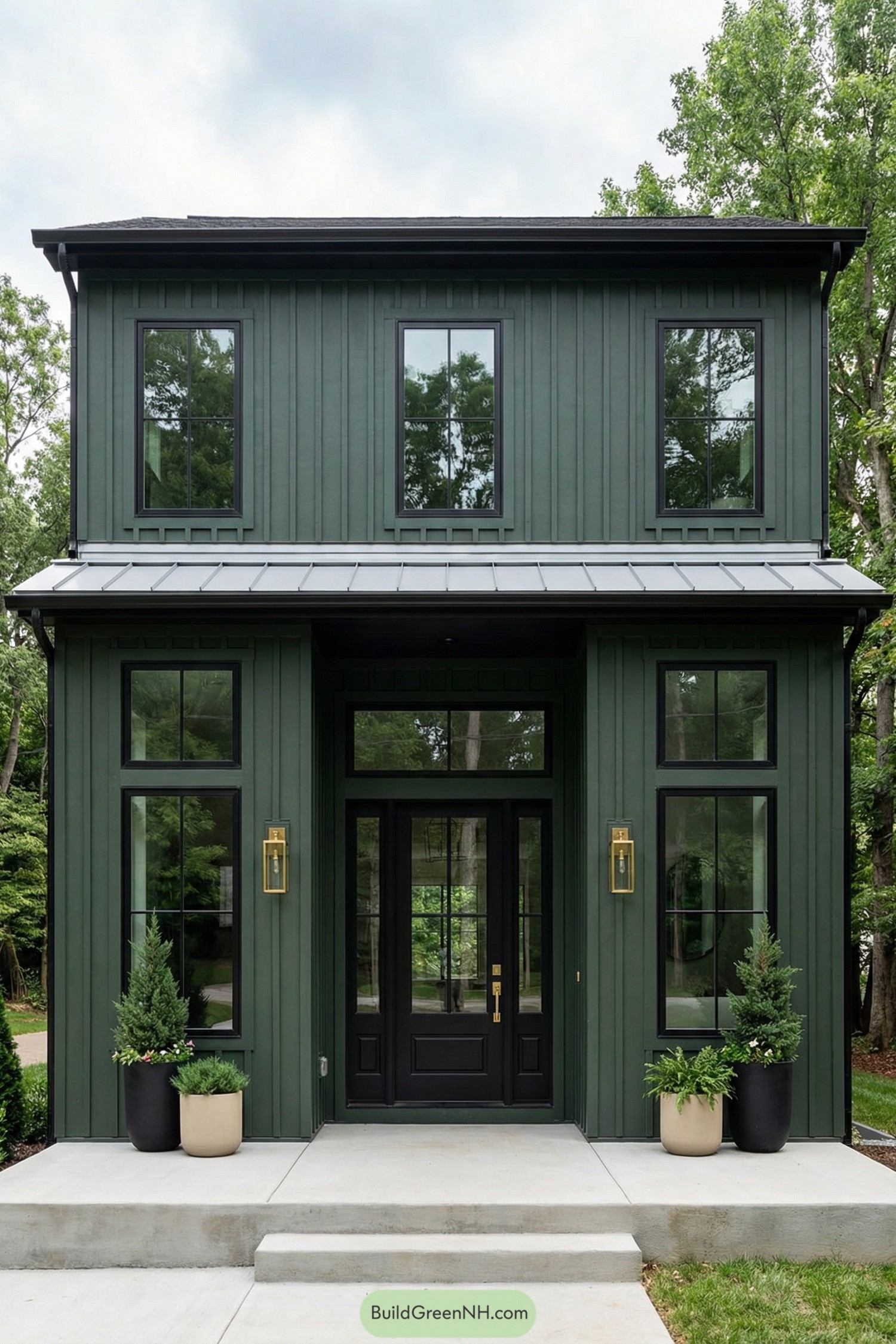 Modern green two-story house with black-framed windows and simple concrete front steps