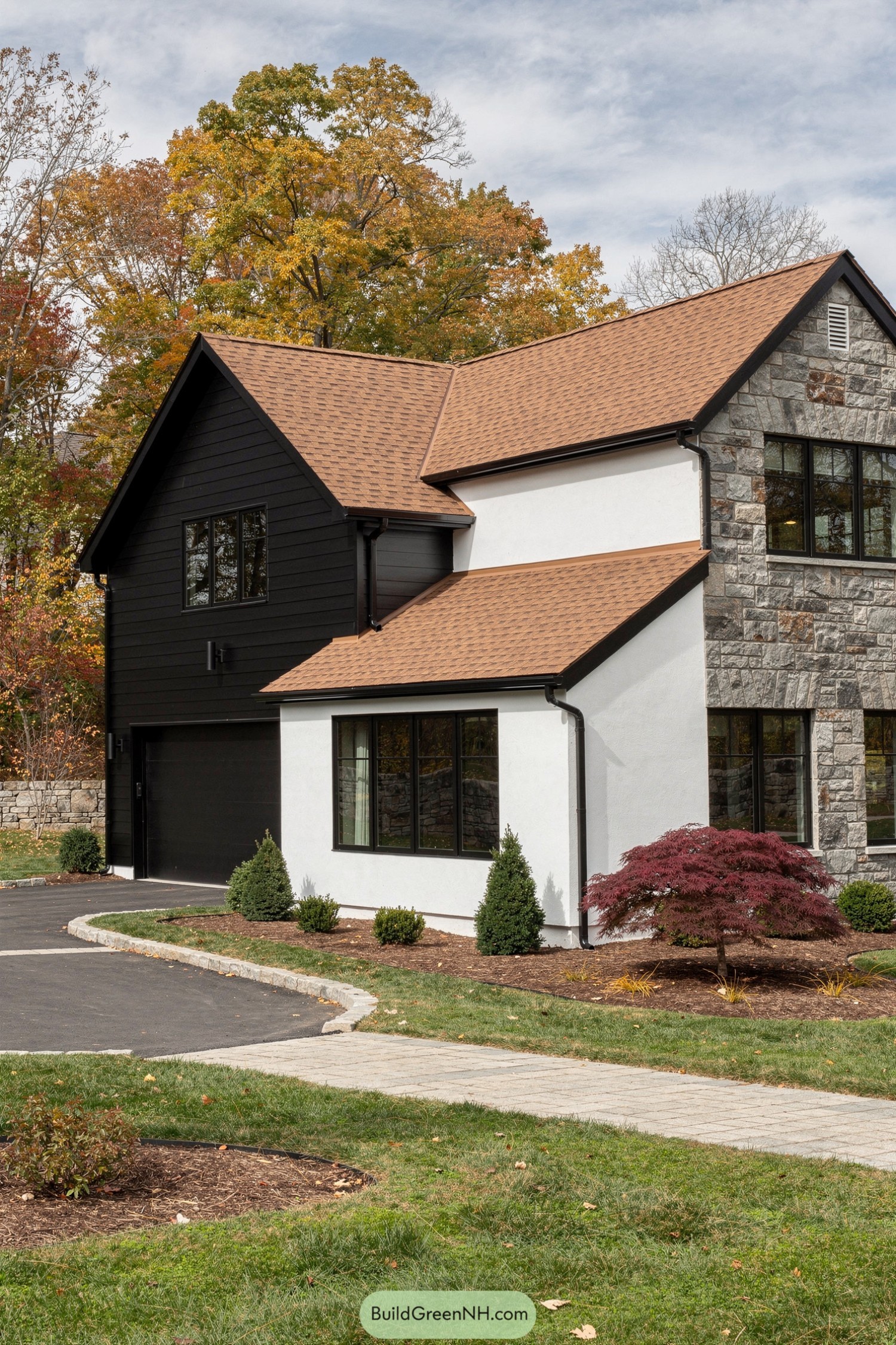 Modern house with black white and stone siding and steep shingle roofs