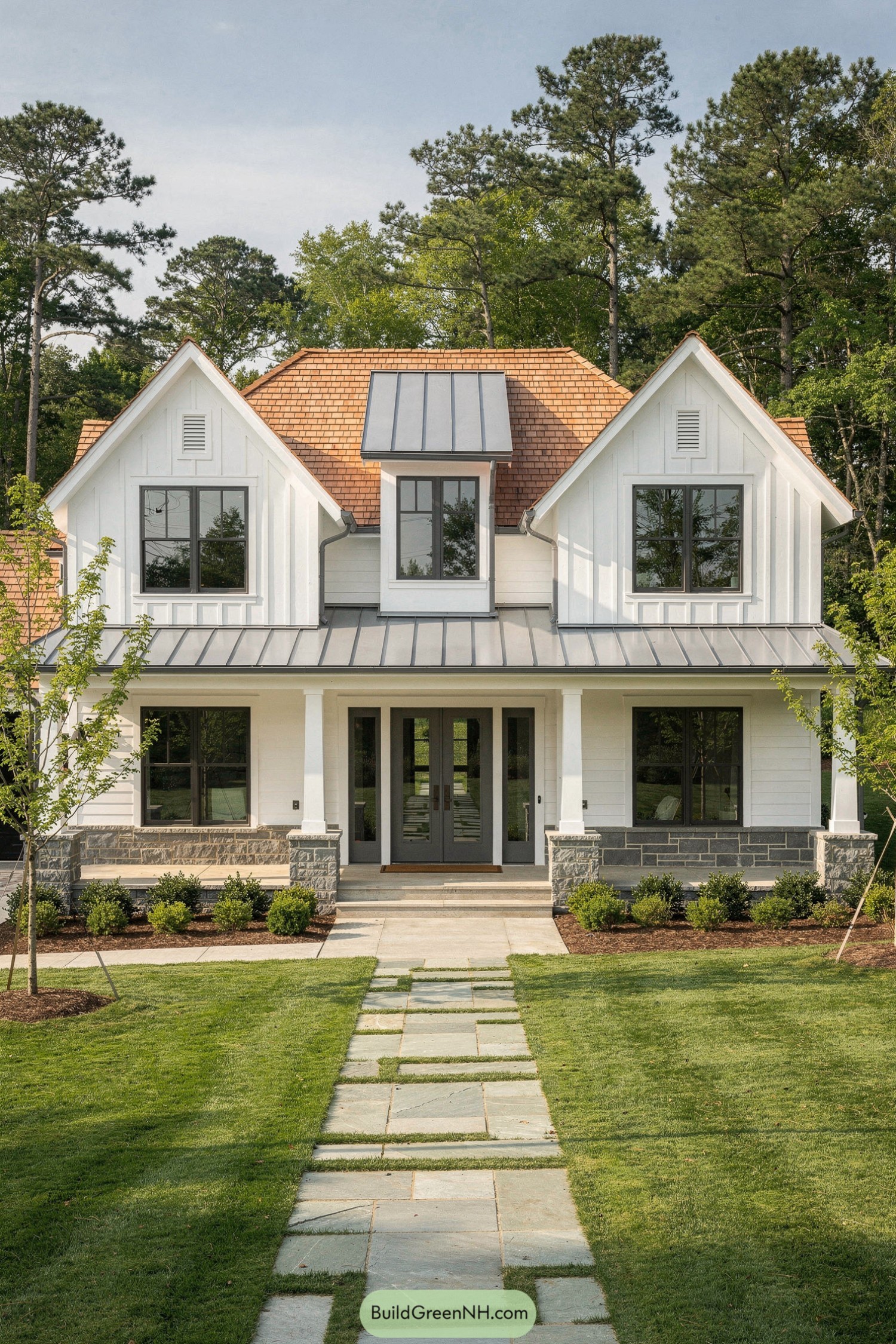 White modern farmhouse with mixed siding and gabled roof surrounded by a neat lawn