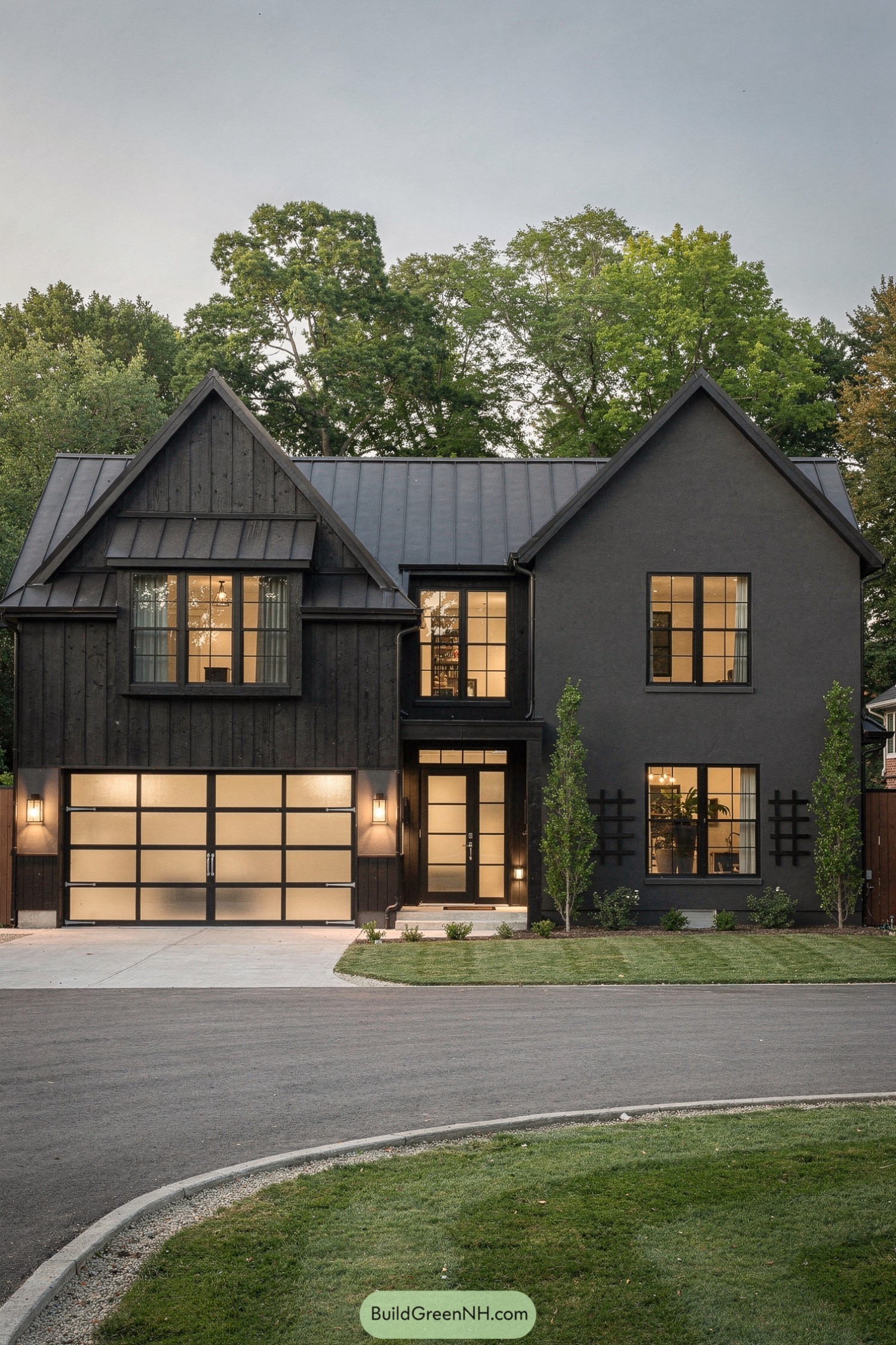 Dark gray modern gabled house with large grid windows and frosted glass garage door