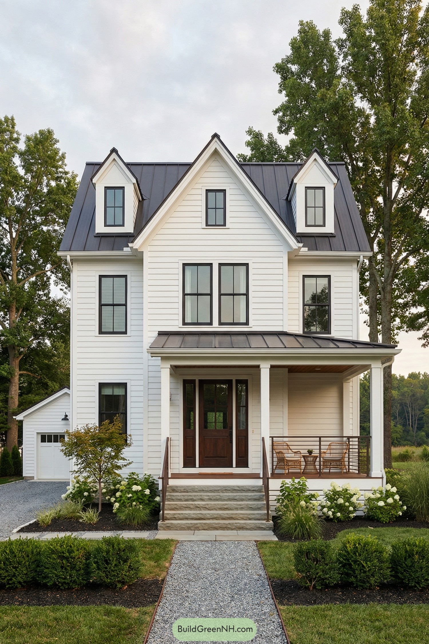 White shiplap farmhouse with steep gables, metal roof, and welcoming front porch with seating