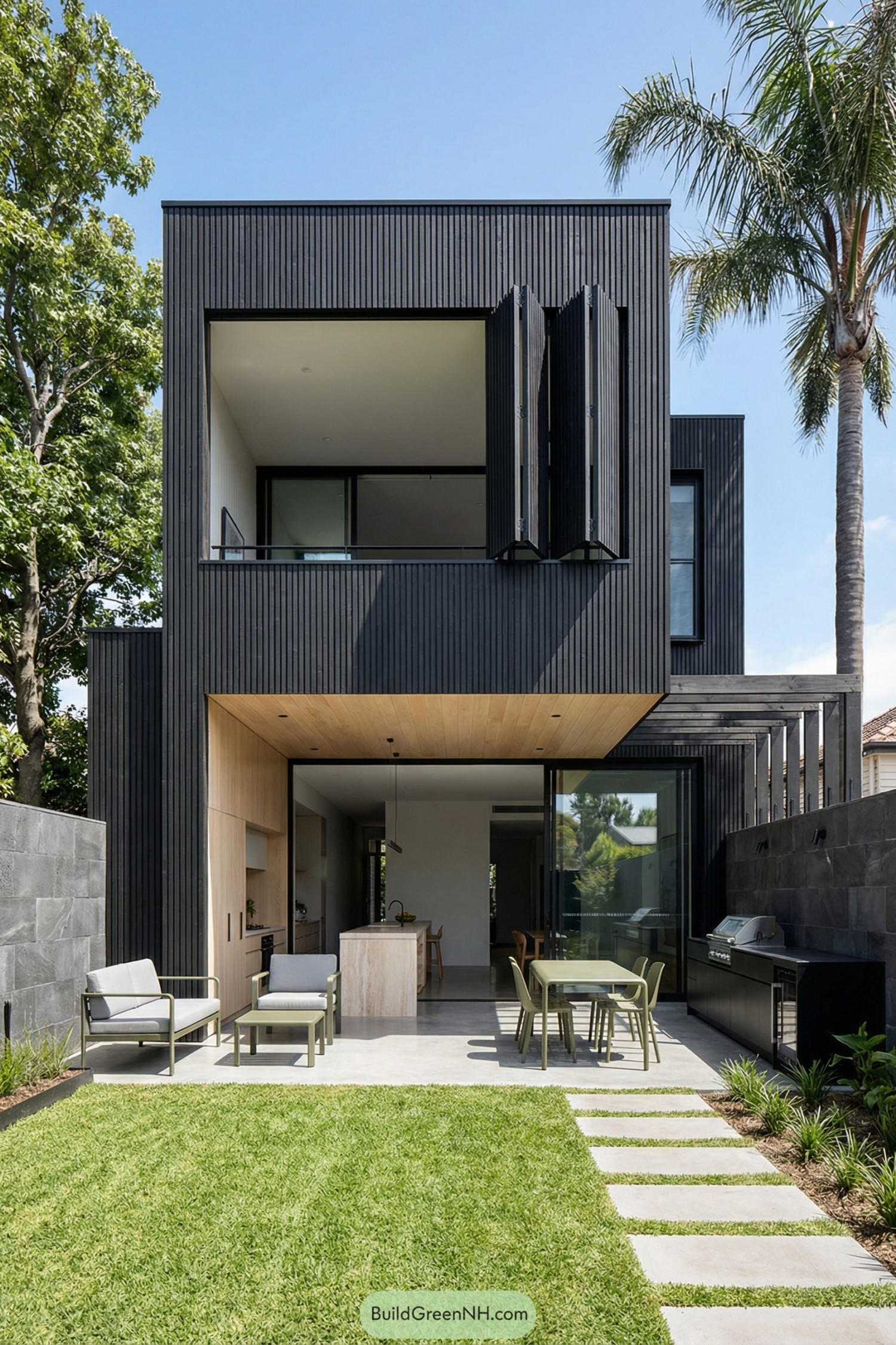 Modern black timber slat house opening to a lawn and outdoor living area