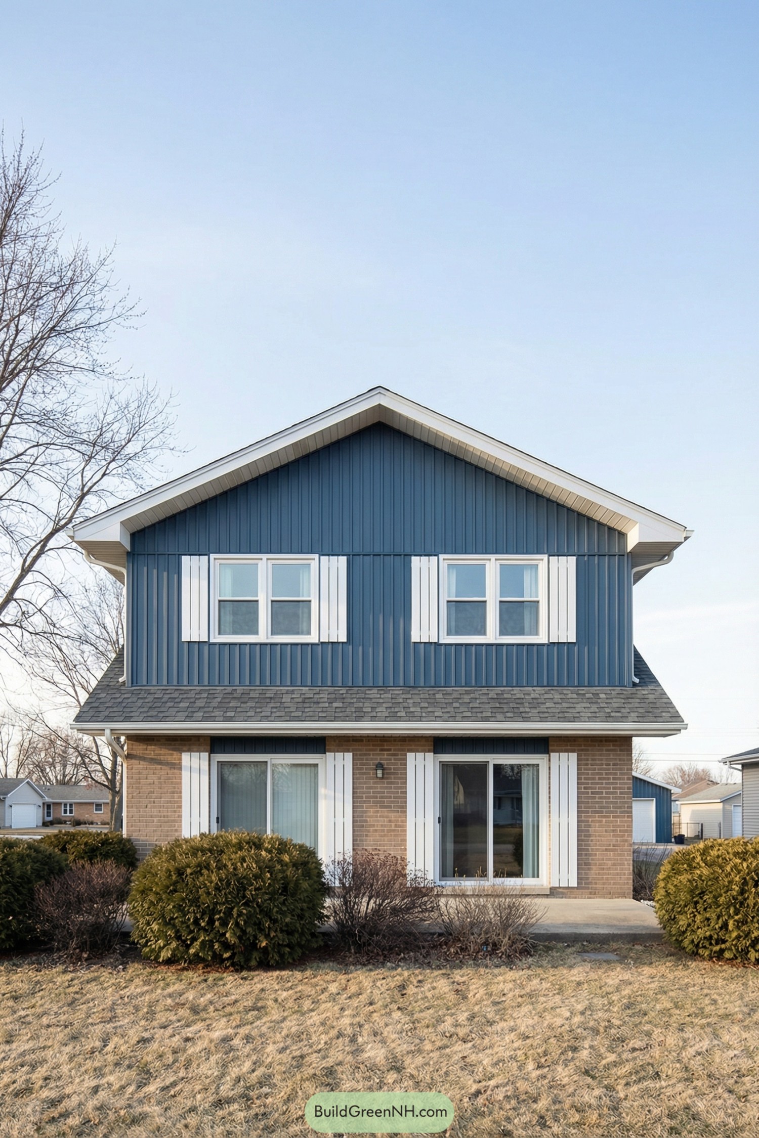 Two-story house with blue vertical siding, white trim, and brick lower level