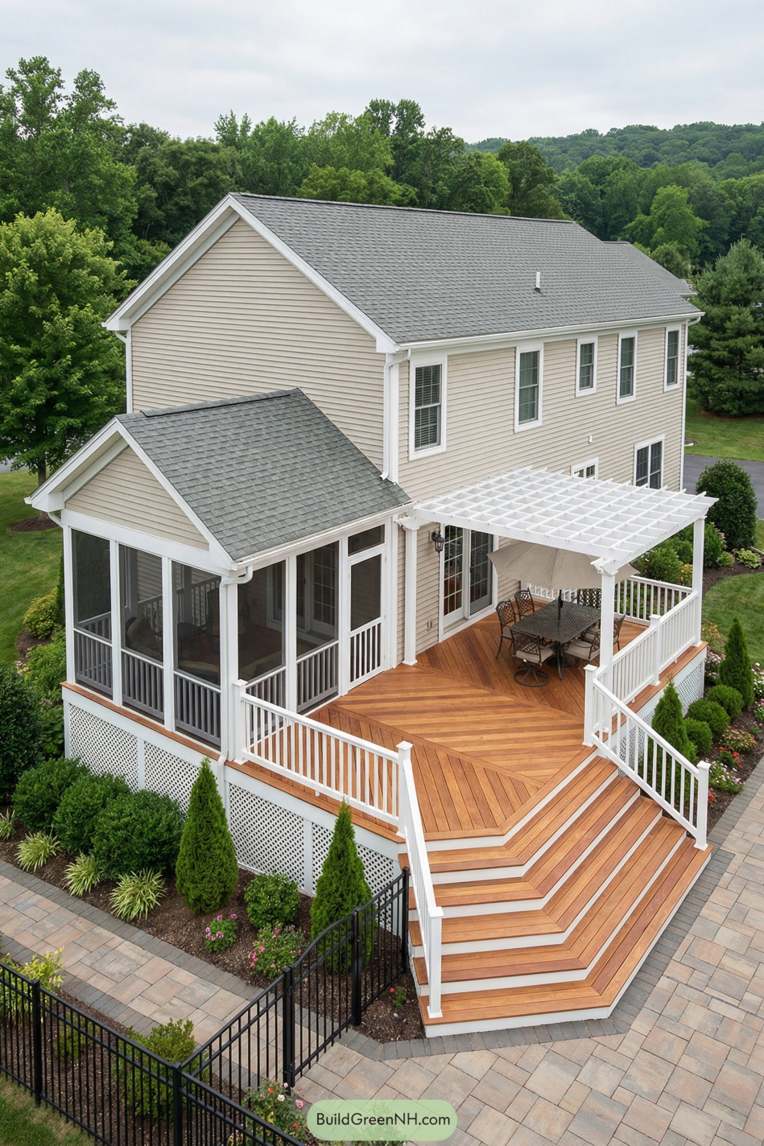 Wide wood deck with angled steps, white railings, and pergola dining beside a screened porch