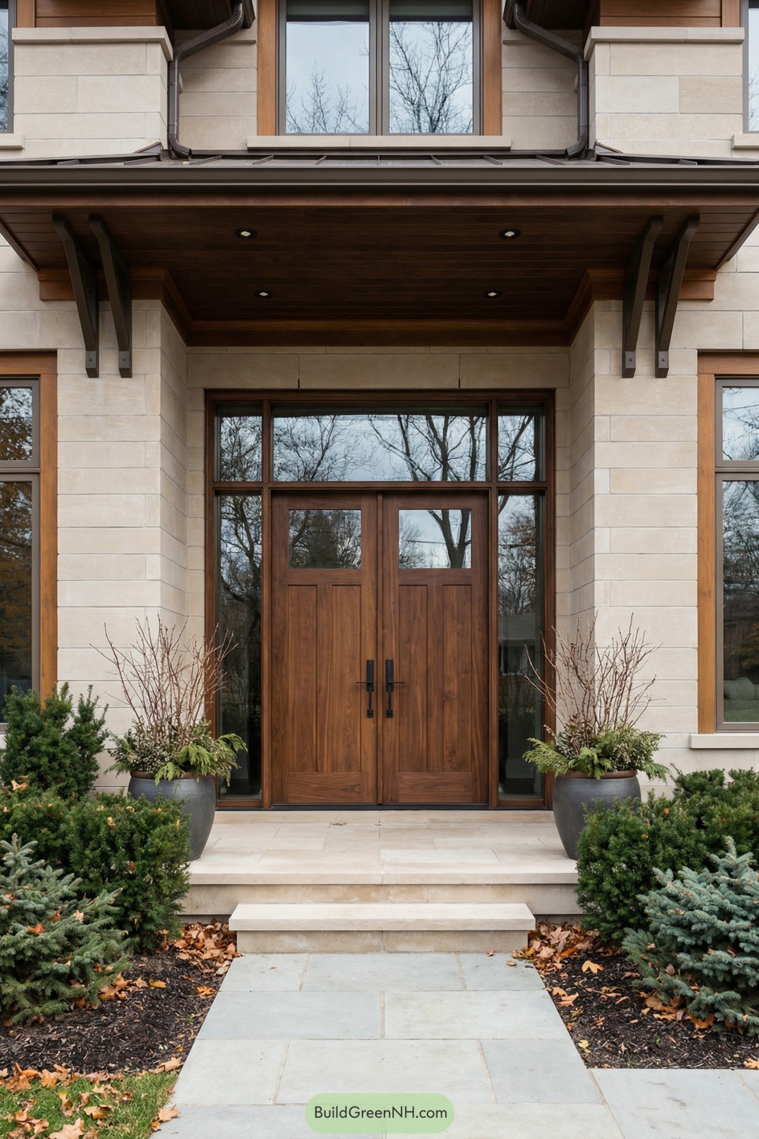Walnut double front doors framed by tall glass and light stone facade