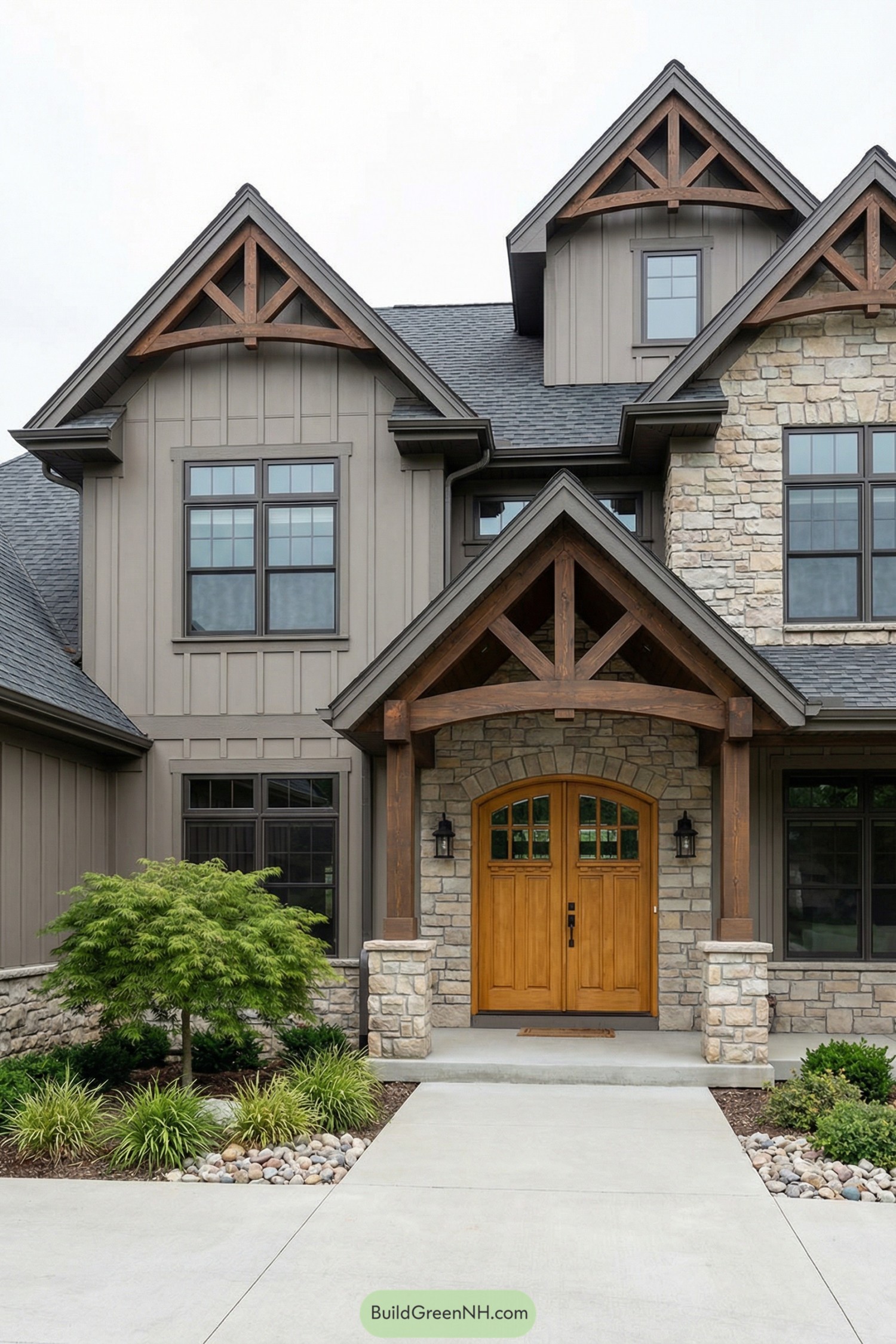 Arched double wood front door beneath timber gable porch on stone and siding farmhouse-style facade