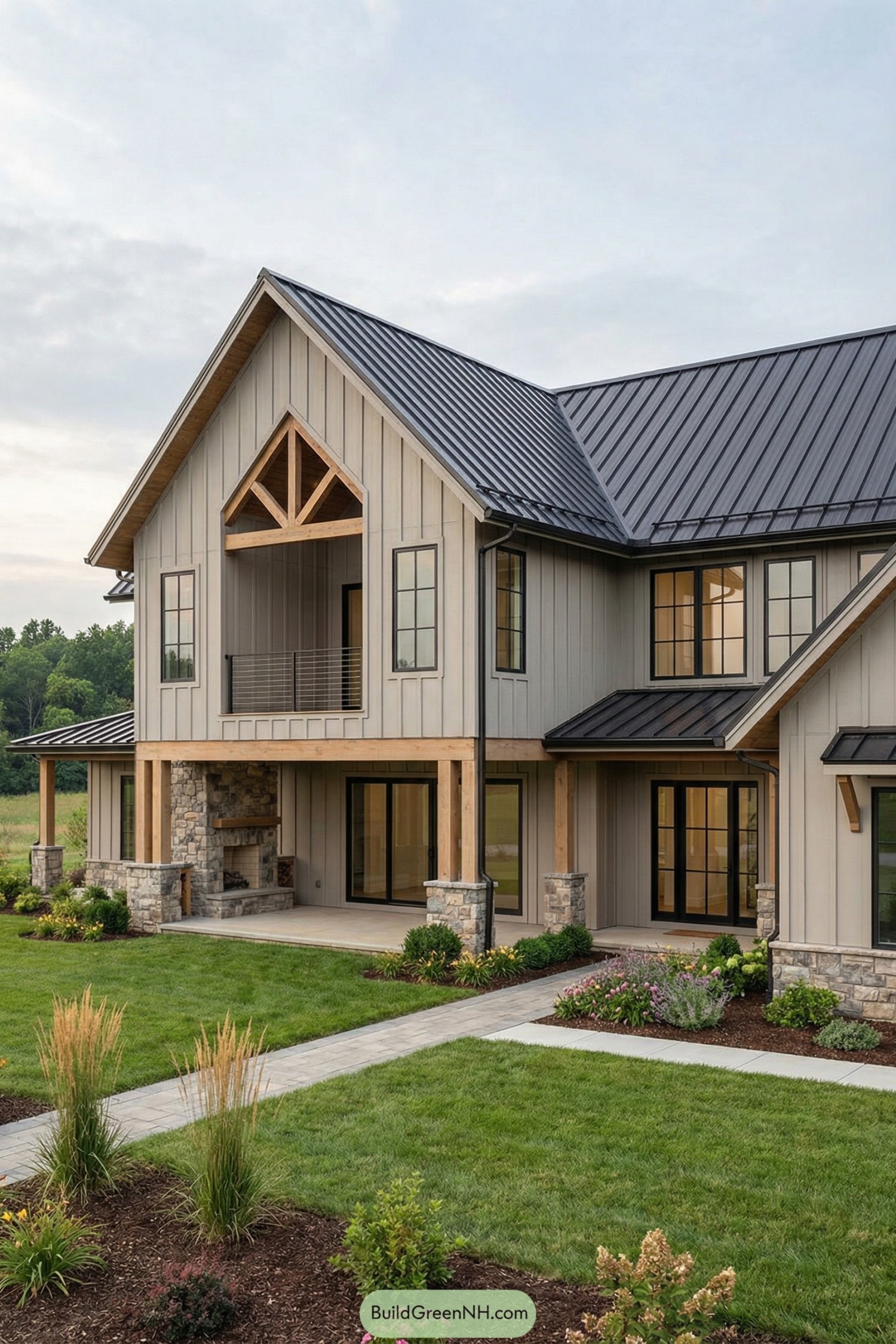 Two-story modern barndominium with vertical board siding, black metal roof, timber beams, and stone-accented porch